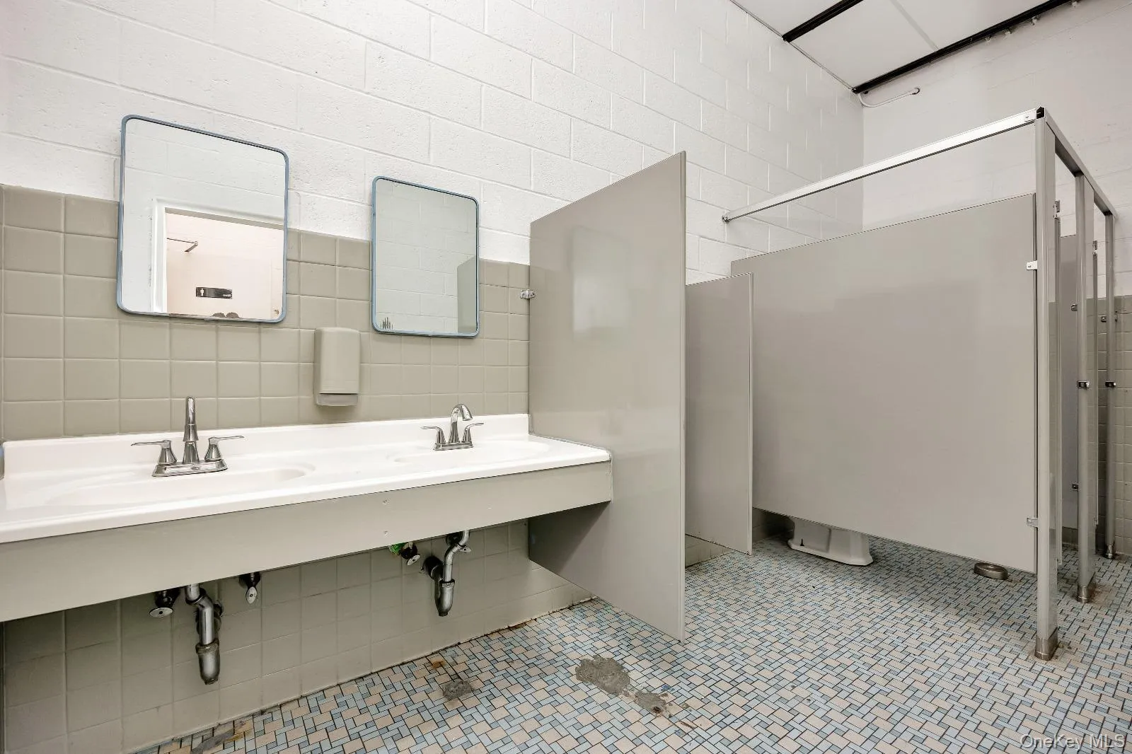 Bathroom with tile walls, a shower stall, and decorative backsplash Bathroom with tile walls, a shower stall, and decorative backsplash