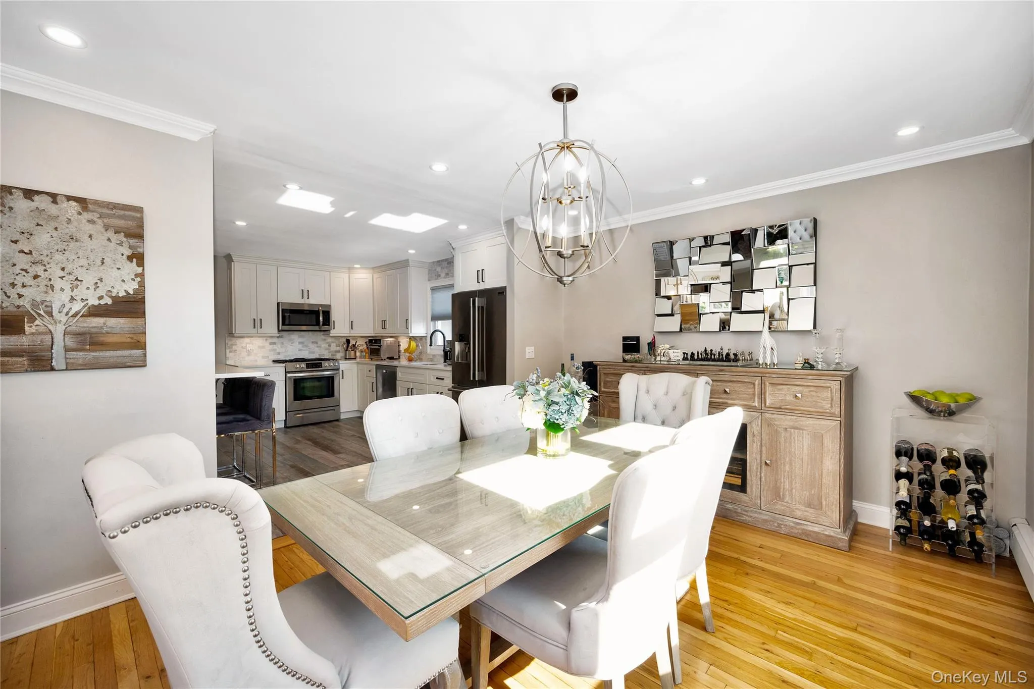 Dining space with ornamental molding, light wood-style flooring, recessed lighting, and a chandelier Dining space with ornamental molding, light wood-style flooring, recessed lighting, and a chandelier