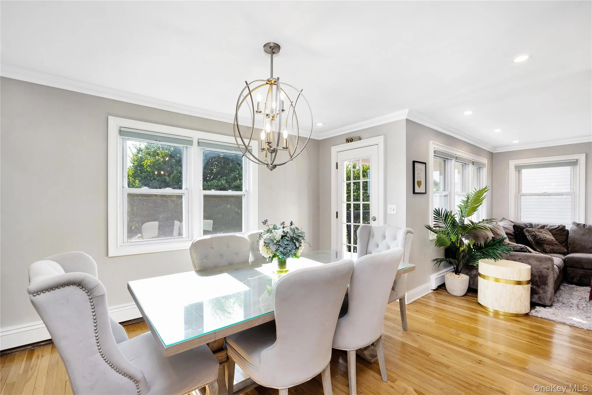 Dining room featuring plenty of natural light, crown molding, light wood-style flooring, a chandelier, and recessed lighting Dining room featuring plenty of natural light, crown molding, light wood-style flooring, a chandelier, and recessed lighting