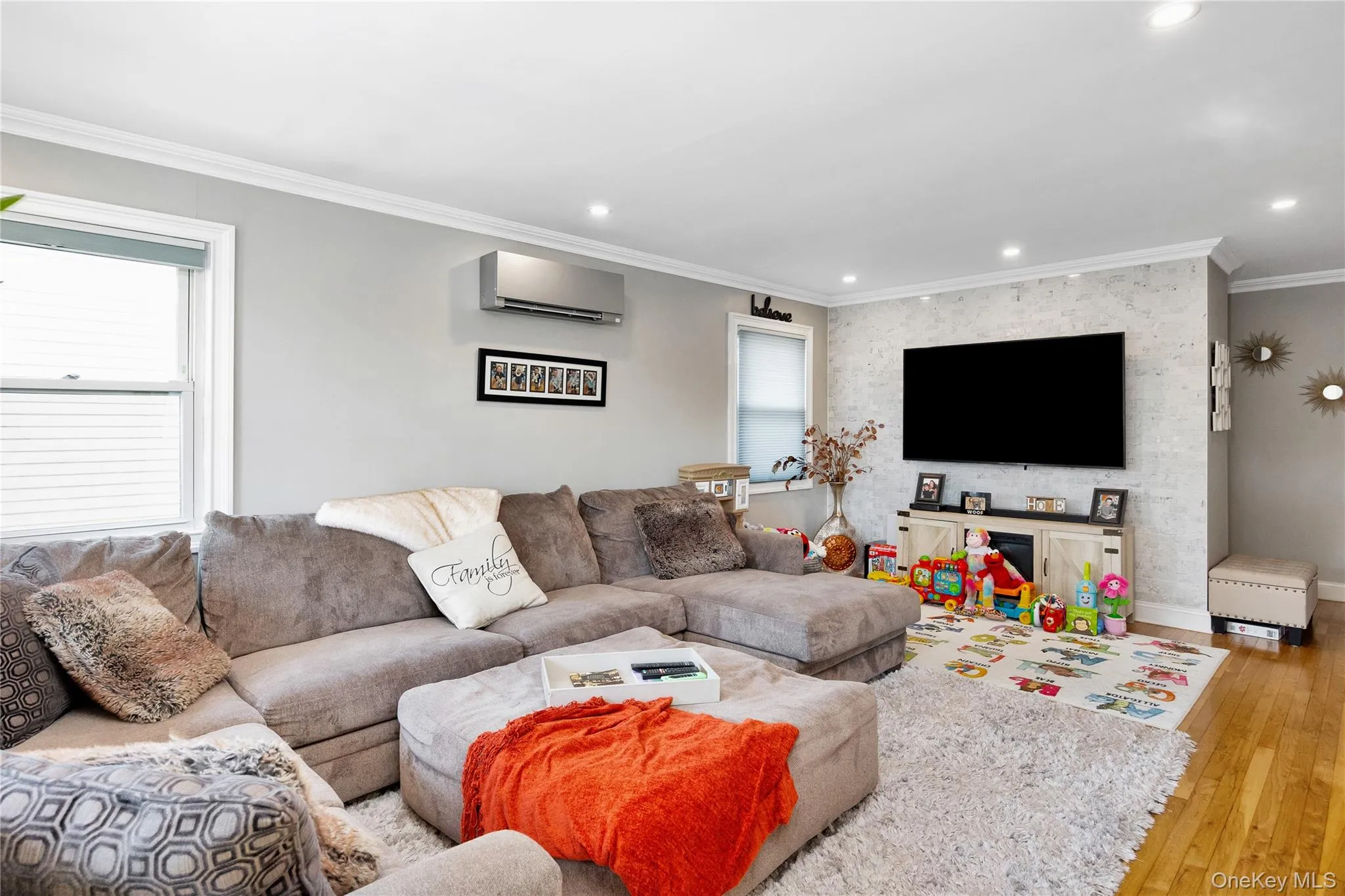 Living room with ornamental molding, hardwood / wood-style floors, recessed lighting, healthy amount of natural light, and a wall mounted air conditioner Living room with ornamental molding, hardwood / wood-style floors, recessed lighting, healthy amount of natural light, and a wall mounted air conditioner