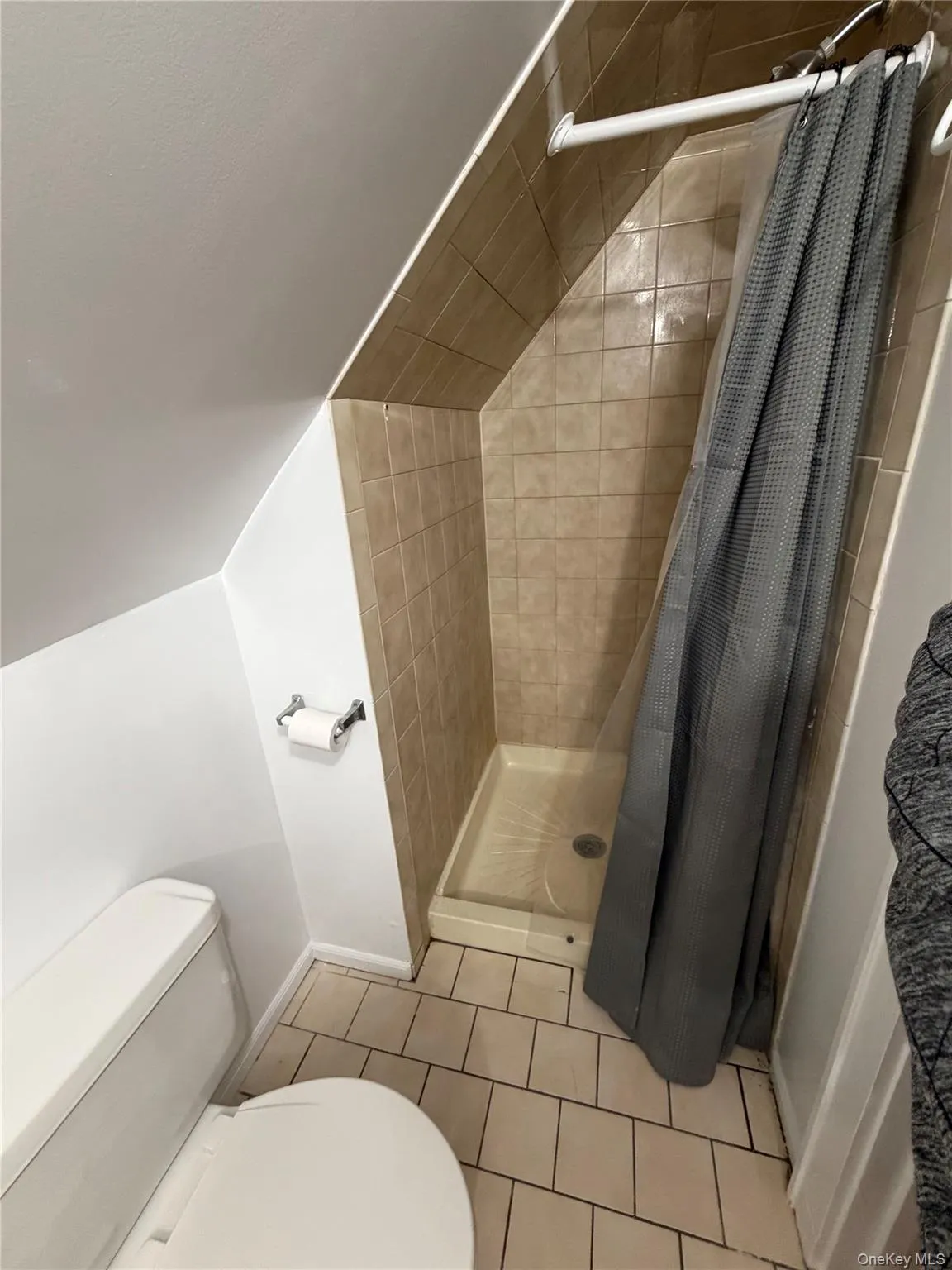 Bathroom featuring a shower stall and light tile patterned floors Bathroom featuring a shower stall and light tile patterned floors