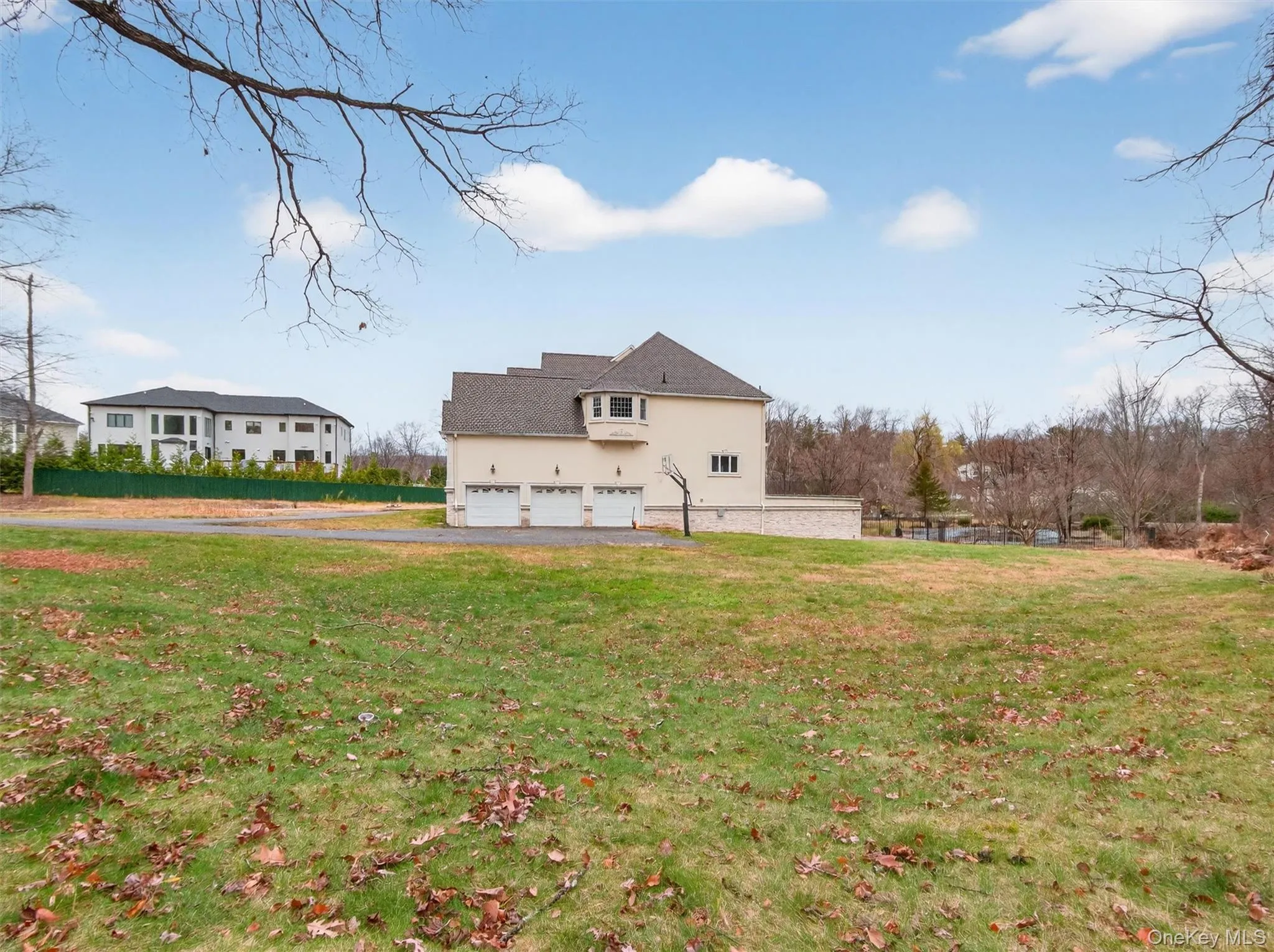 Rear view of house with a lawn, stucco siding, asphalt driveway, and a garage Rear view of house with a lawn, stucco siding, asphalt driveway, and a garage