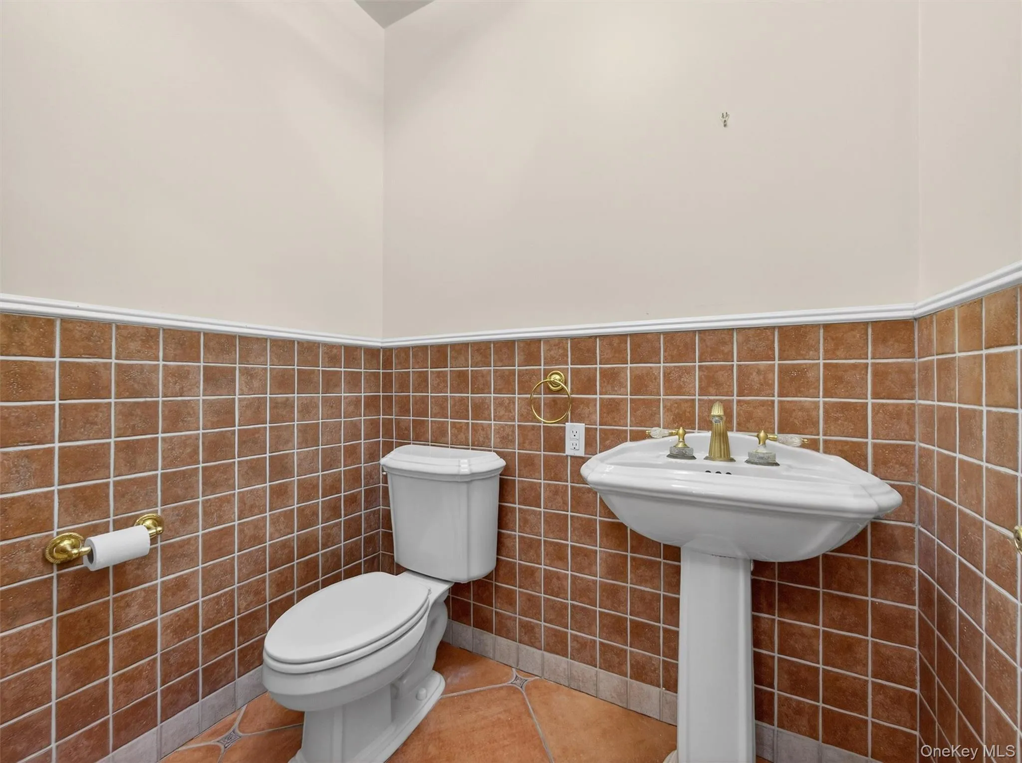 Half bathroom featuring wainscoting, tile patterned flooring, and tile walls Half bathroom featuring wainscoting, tile patterned flooring, and tile walls