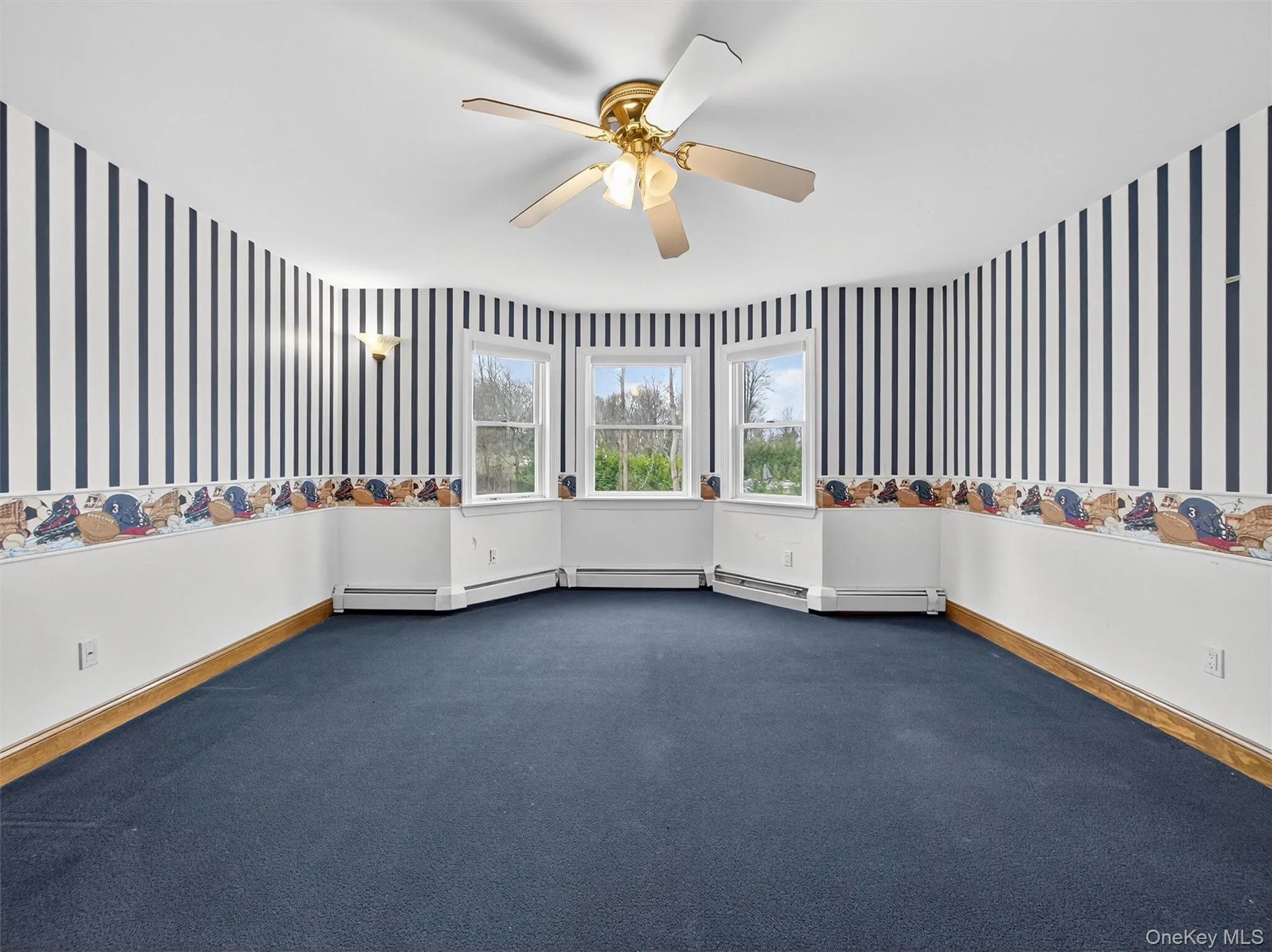 Carpeted empty room with wallpapered walls and a ceiling fan Carpeted empty room with wallpapered walls and a ceiling fan