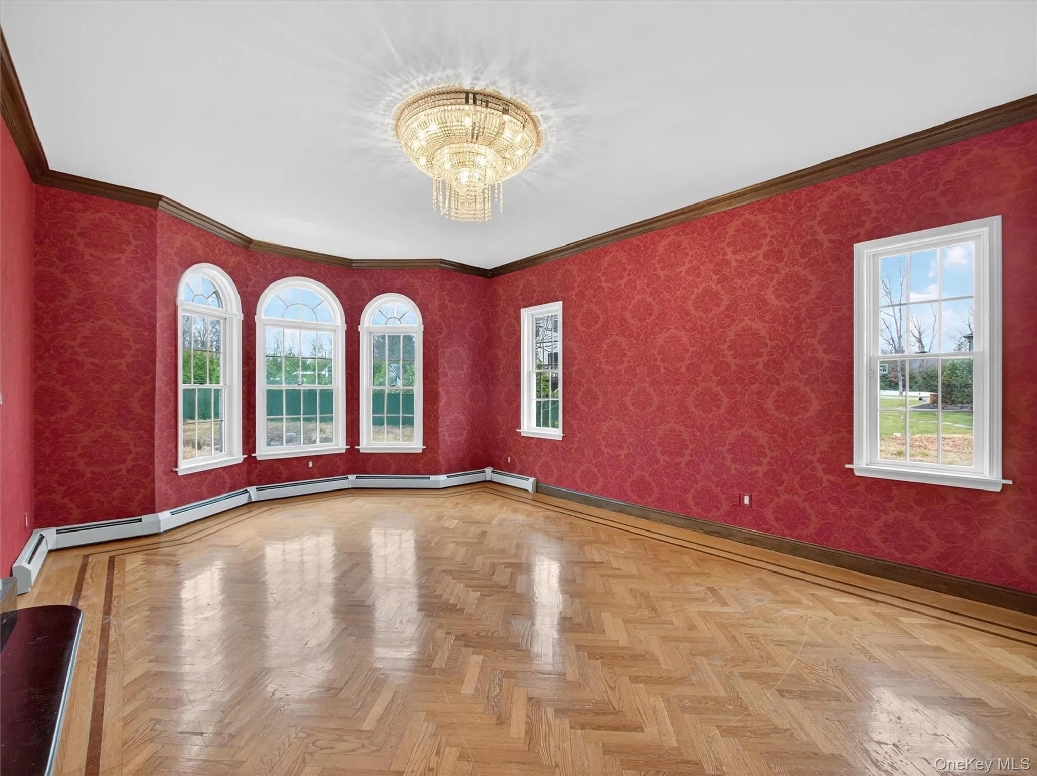 Spare room featuring wallpapered walls, a chandelier, ornamental molding, and healthy amount of natural light Spare room featuring wallpapered walls, a chandelier, ornamental molding, and healthy amount of natural light