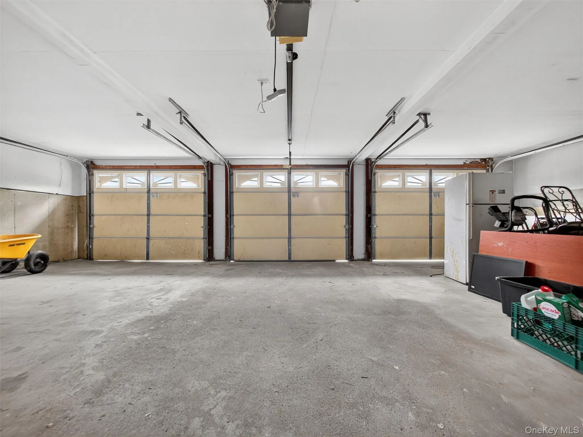 Garage featuring freestanding refrigerator and a garage door opener Garage featuring freestanding refrigerator and a garage door opener