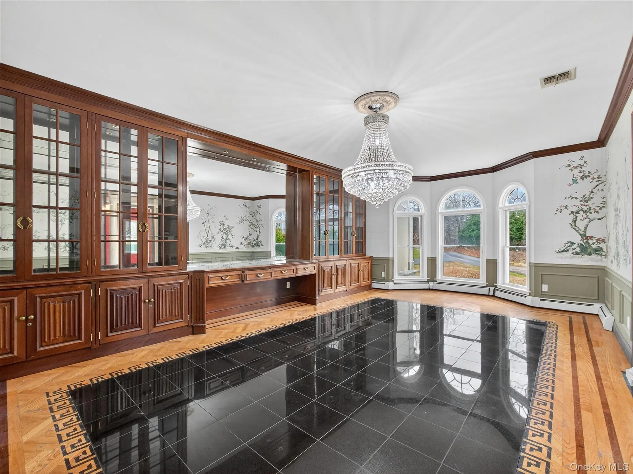 Unfurnished dining area with a wainscoted wall, a decorative wall, crown molding, a chandelier, and a baseboard heating unit Unfurnished dining area with a wainscoted wall, a decorative wall, crown molding, a chandelier, and a baseboard heating unit