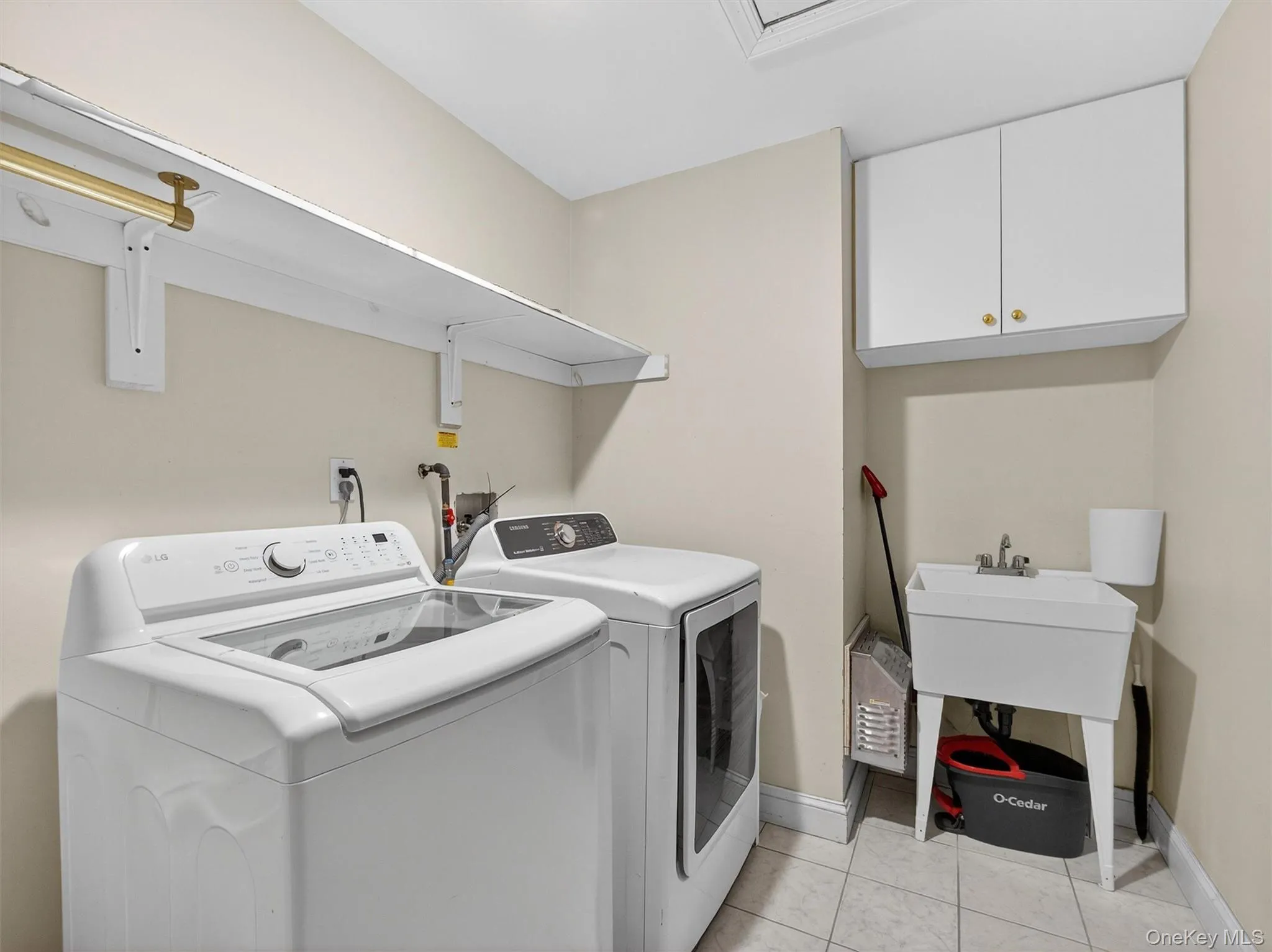 Laundry room with light tile patterned floors, washing machine and dryer, and cabinet space Laundry room with light tile patterned floors, washing machine and dryer, and cabinet space