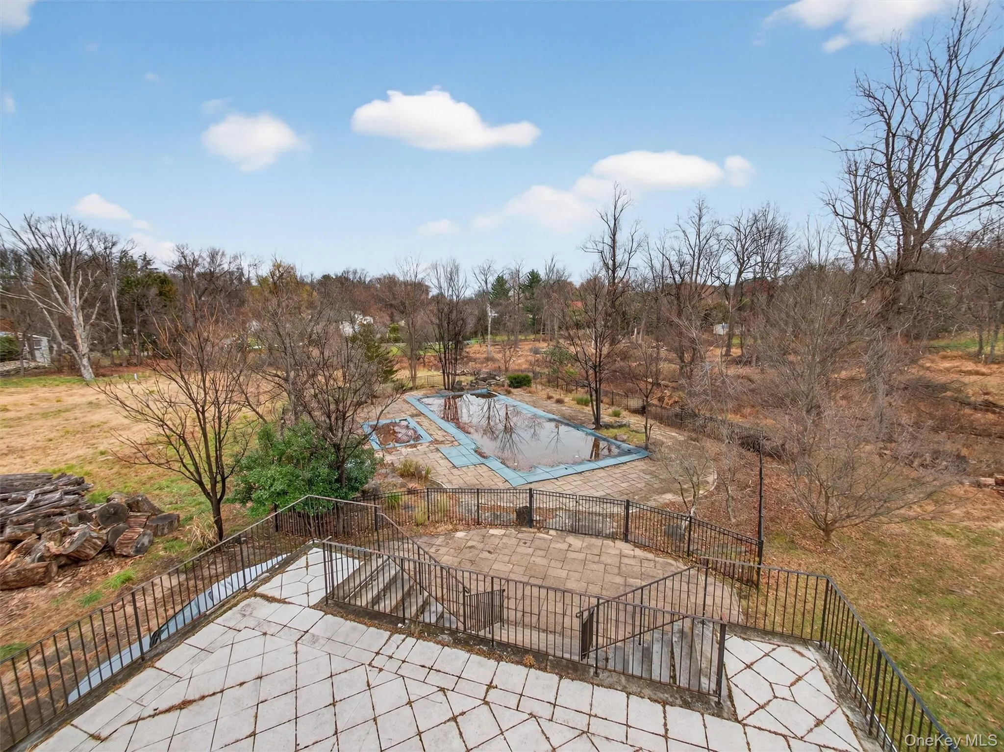 View of swimming pool featuring a patio, a covered pool, and view of scattered trees View of swimming pool featuring a patio, a covered pool, and view of scattered trees
