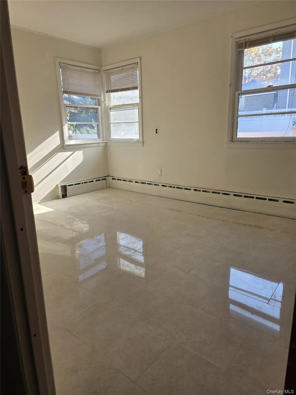 Spare room with healthy amount of natural light and baseboard heating Spare room with healthy amount of natural light and baseboard heating