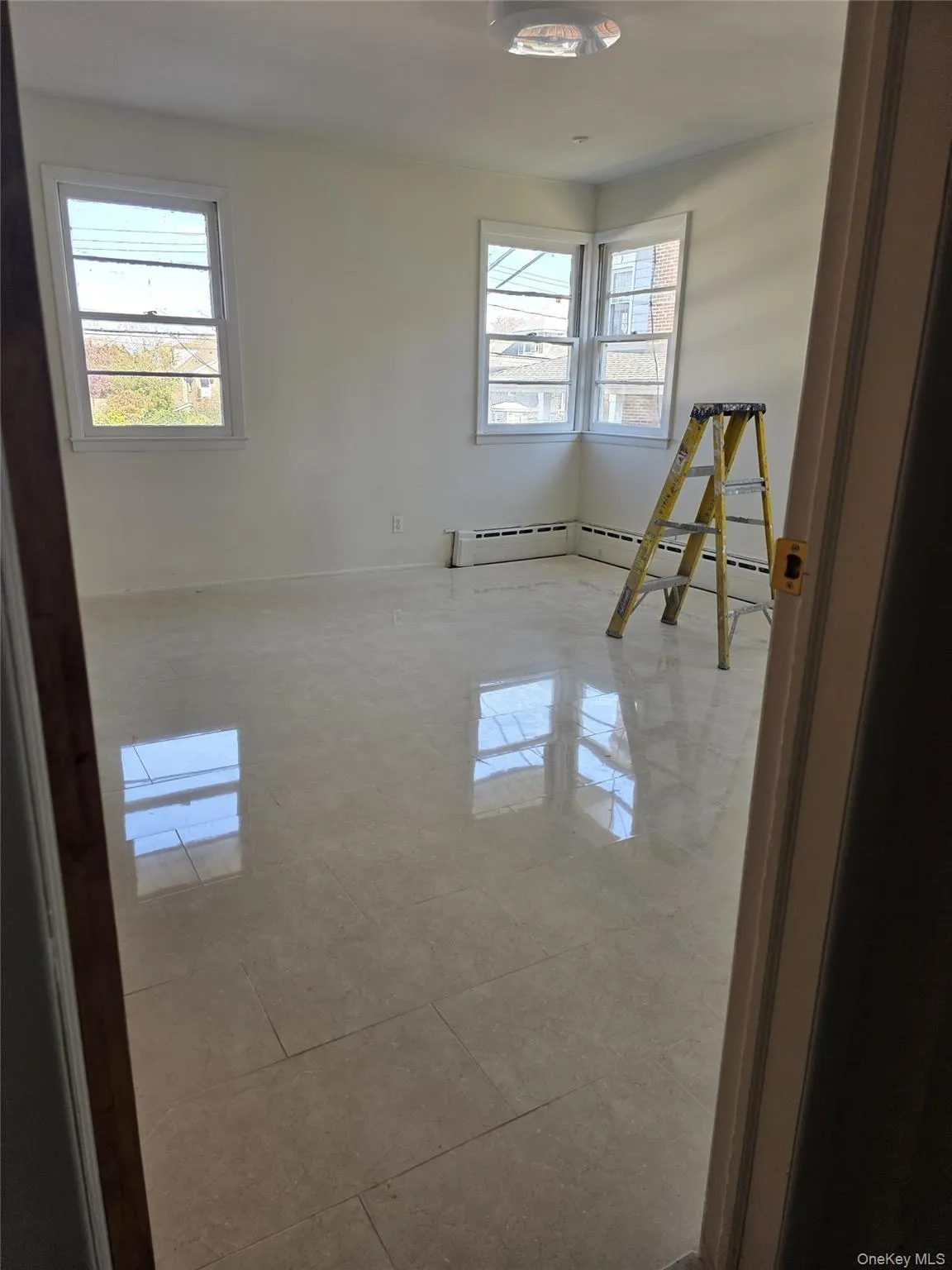 Unfurnished room featuring a baseboard heating unit and tile patterned flooring Unfurnished room featuring a baseboard heating unit and tile patterned flooring