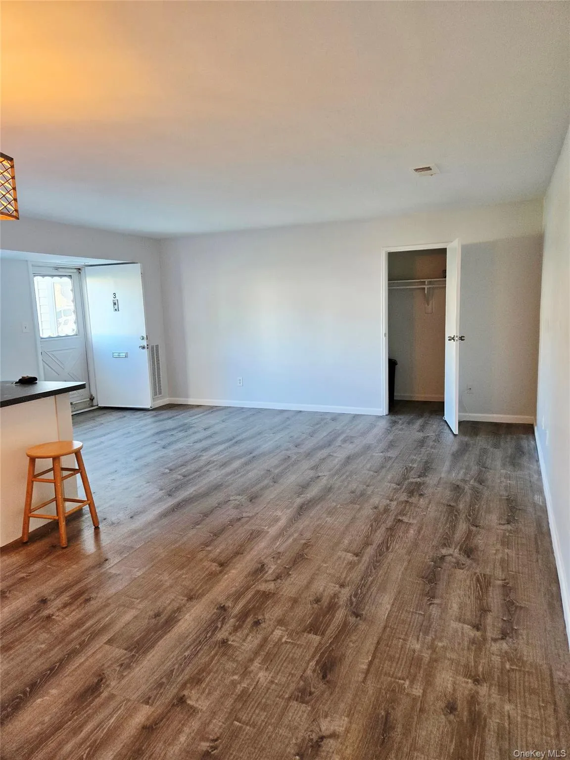 Unfurnished living room featuring dark wood finished floors and baseboards Unfurnished living room featuring dark wood finished floors and baseboards