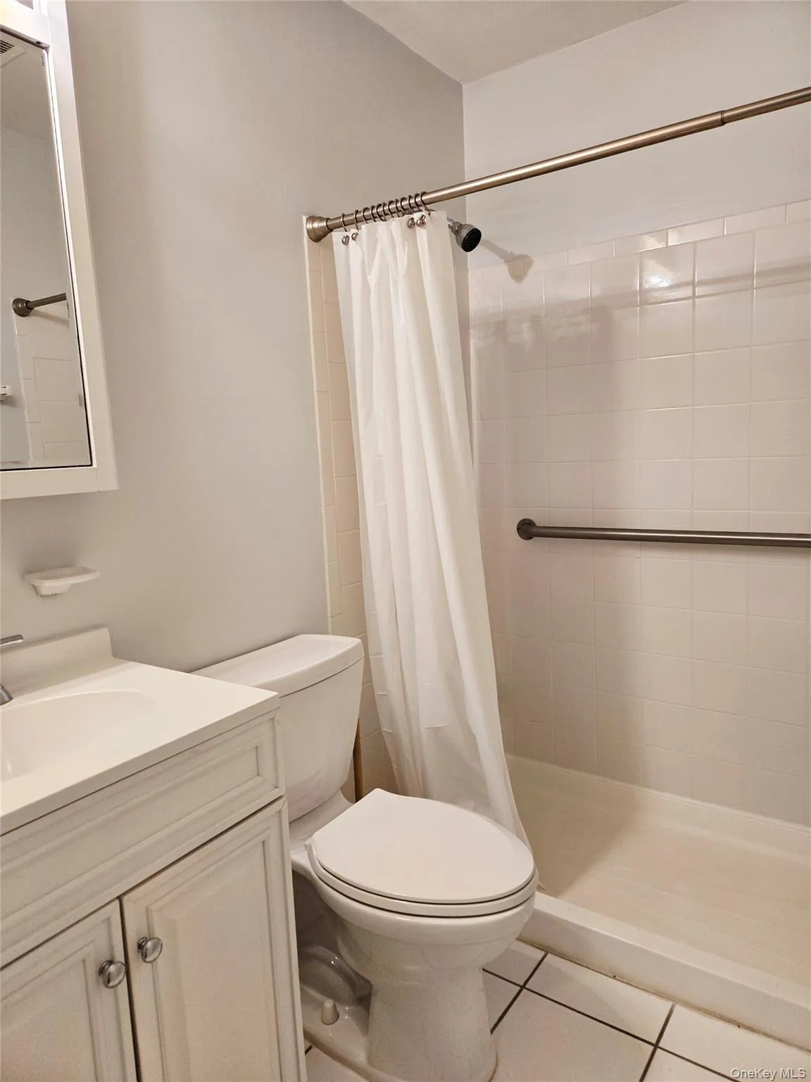 Full bath with tile patterned flooring, vanity, and a stall shower Full bath with tile patterned flooring, vanity, and a stall shower