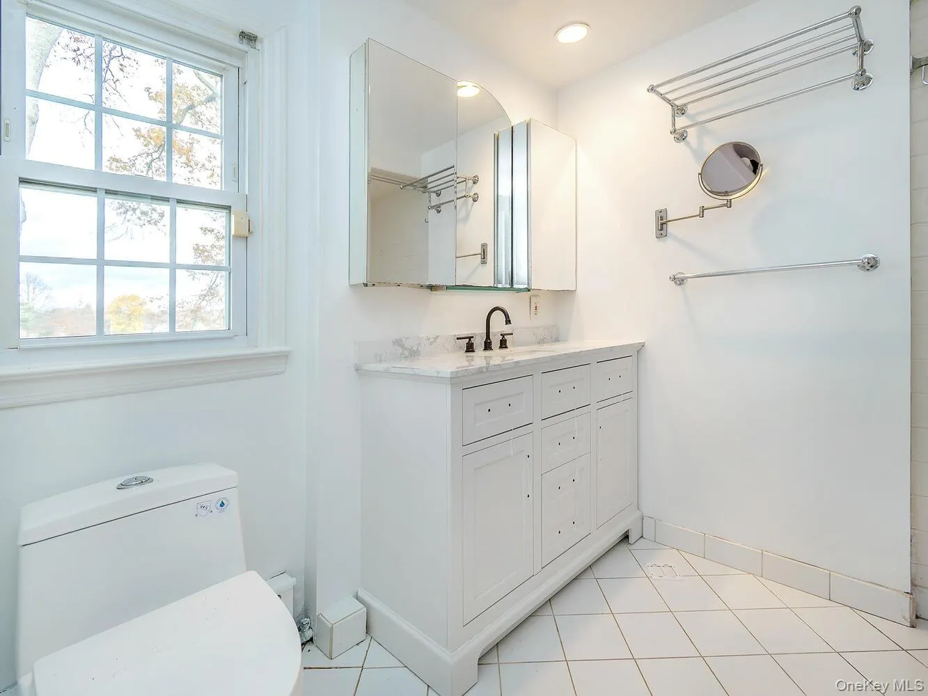Bathroom featuring light tile patterned floors and vanity Bathroom featuring light tile patterned floors and vanity