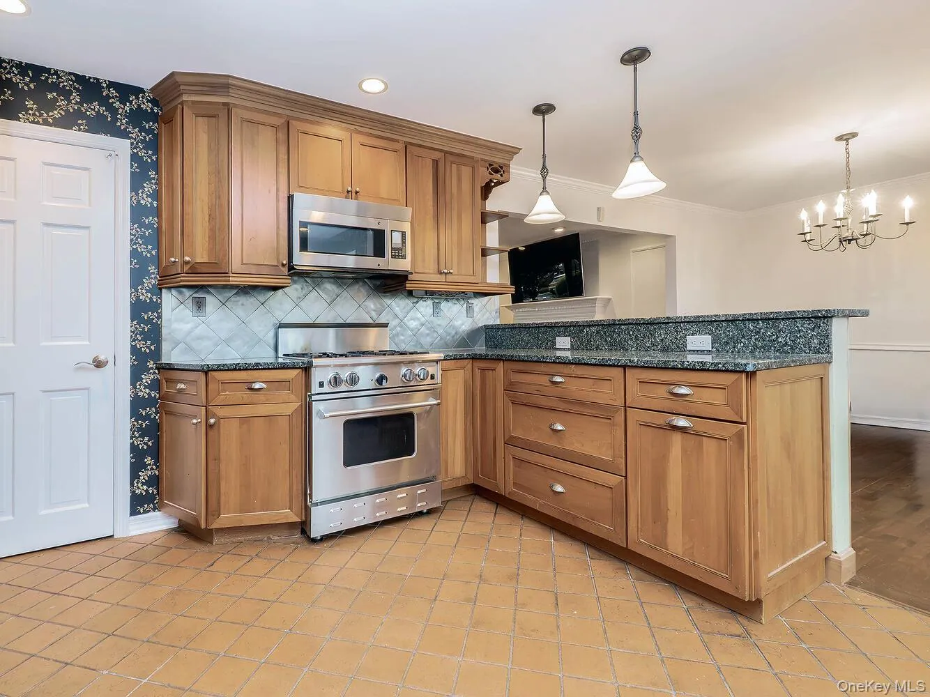 Kitchen featuring brown cabinetry, appliances with stainless steel finishes, tasteful backsplash, dark stone countertops, and recessed lighting Kitchen featuring brown cabinetry, appliances with stainless steel finishes, tasteful backsplash, dark stone countertops, and recessed lighting