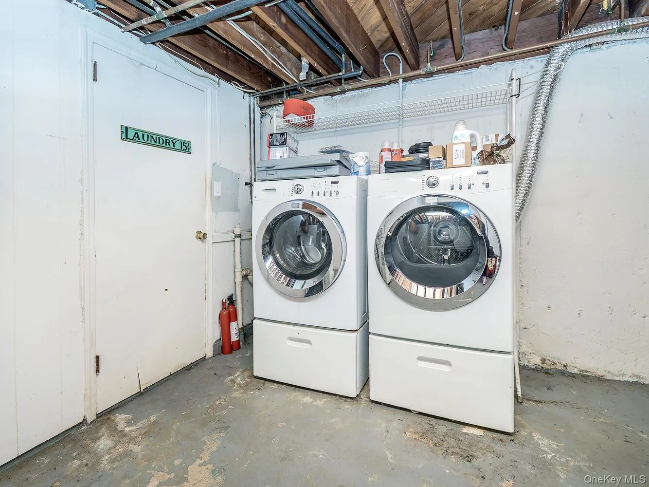 Laundry room featuring concrete flooring and washer and dryer Laundry room featuring concrete flooring and washer and dryer