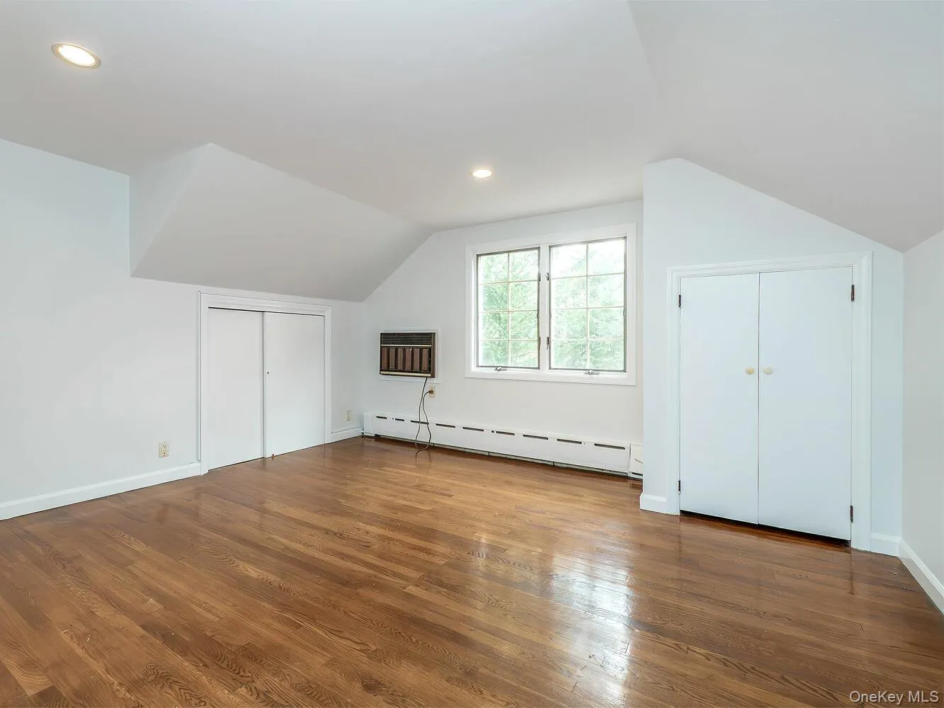 Bonus room with a baseboard radiator, wood finished floors, recessed lighting, an AC wall unit, and vaulted ceiling Bonus room with a baseboard radiator, wood finished floors, recessed lighting, an AC wall unit, and vaulted ceiling