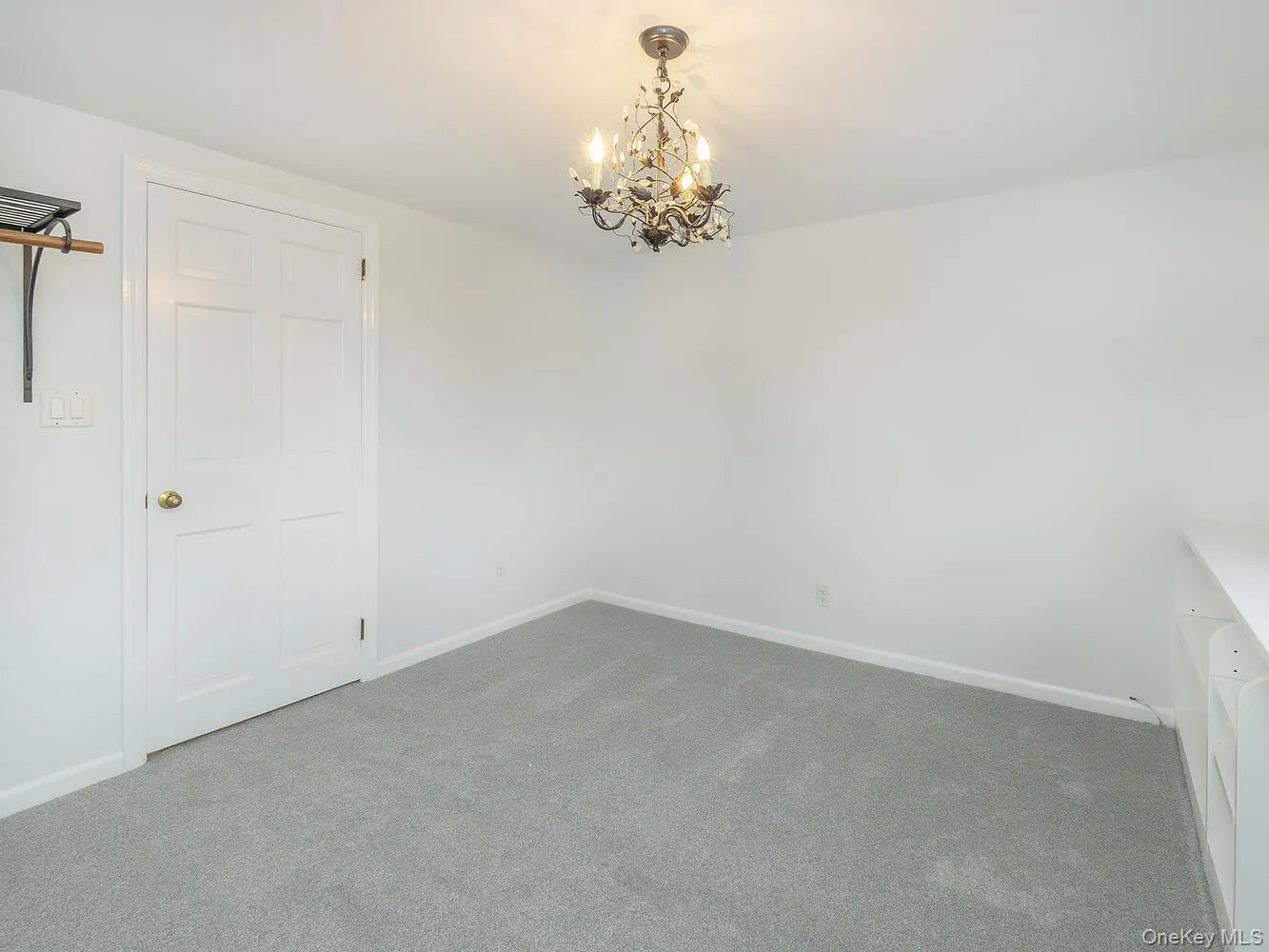 Unfurnished bedroom with carpet and a chandelier Unfurnished bedroom with carpet and a chandelier
