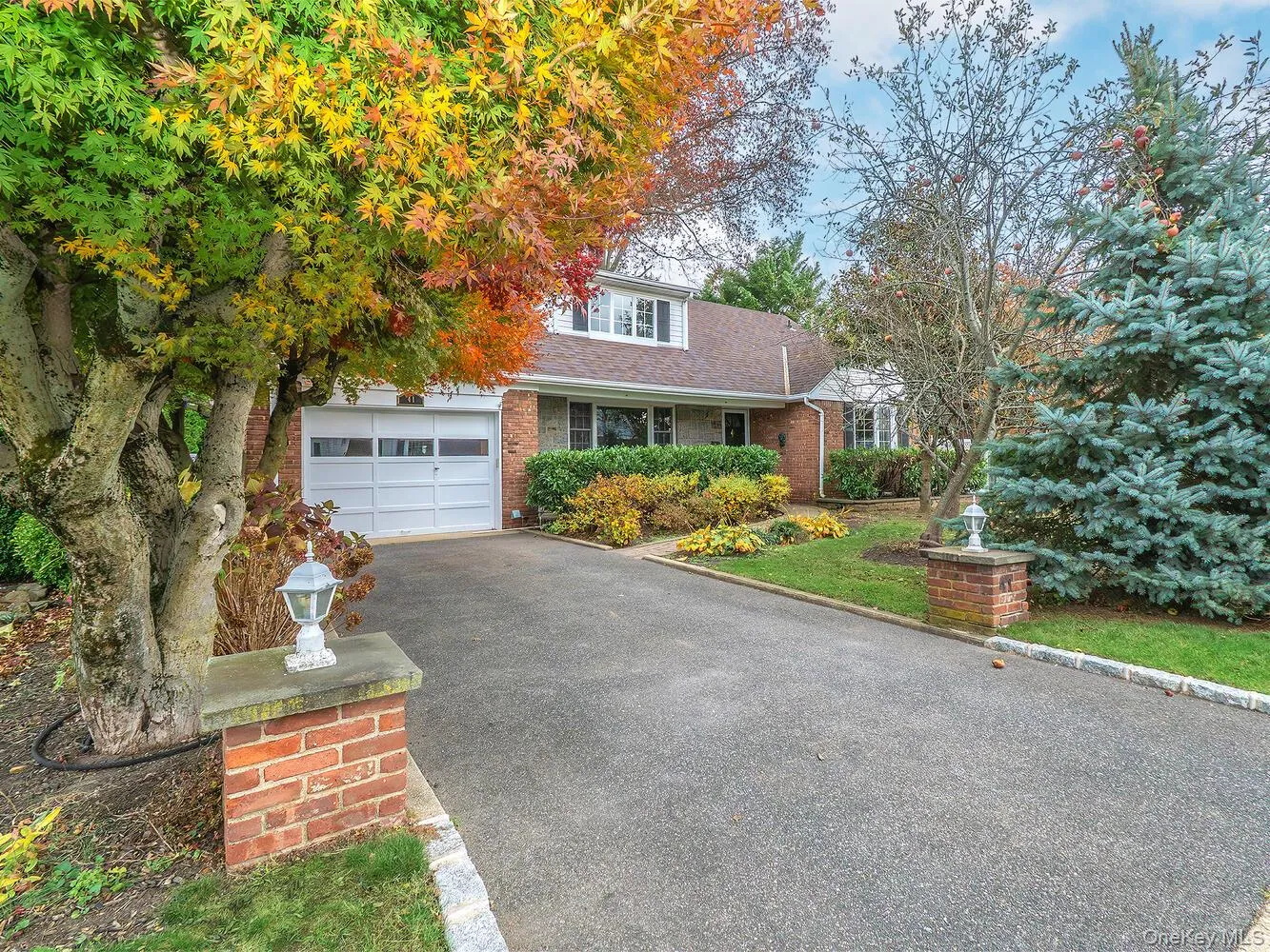 View of front of home featuring a shingled roof, brick siding, driveway, and a garage View of front of home featuring a shingled roof, brick siding, driveway, and a garage