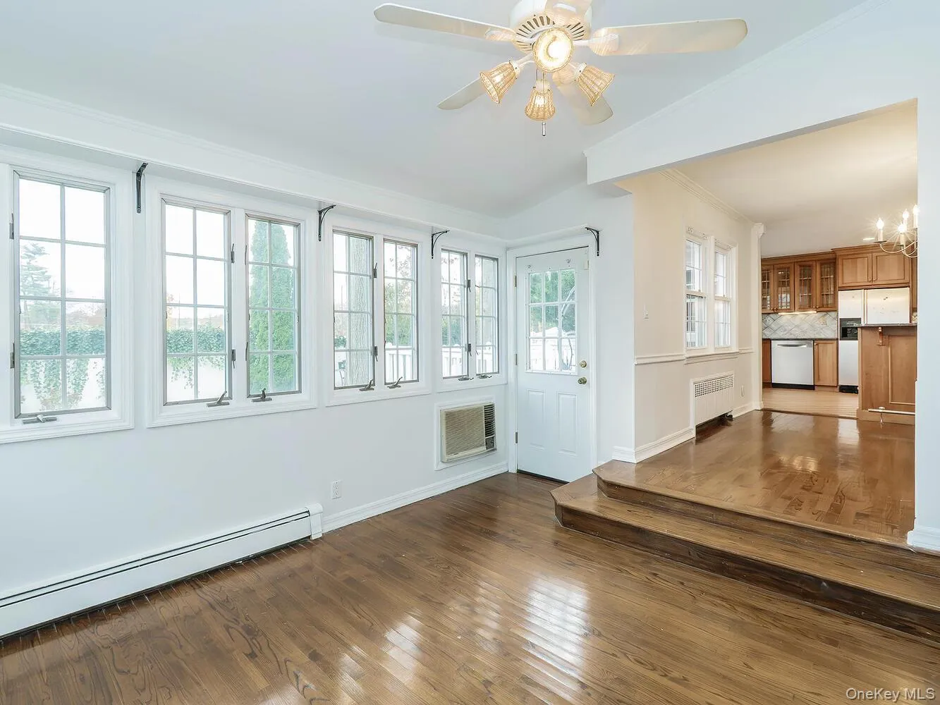 Unfurnished Den with dark wood finished floors, a baseboard heating unit, ornamental molding, radiator heating unit, and a ceiling fan Unfurnished Den with dark wood finished floors, a baseboard heating unit, ornamental molding, radiator heating unit, and a ceiling fan