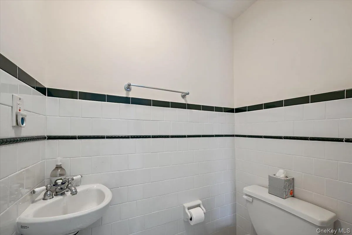 Half bath featuring tile walls and toilet Half bath featuring tile walls and toilet