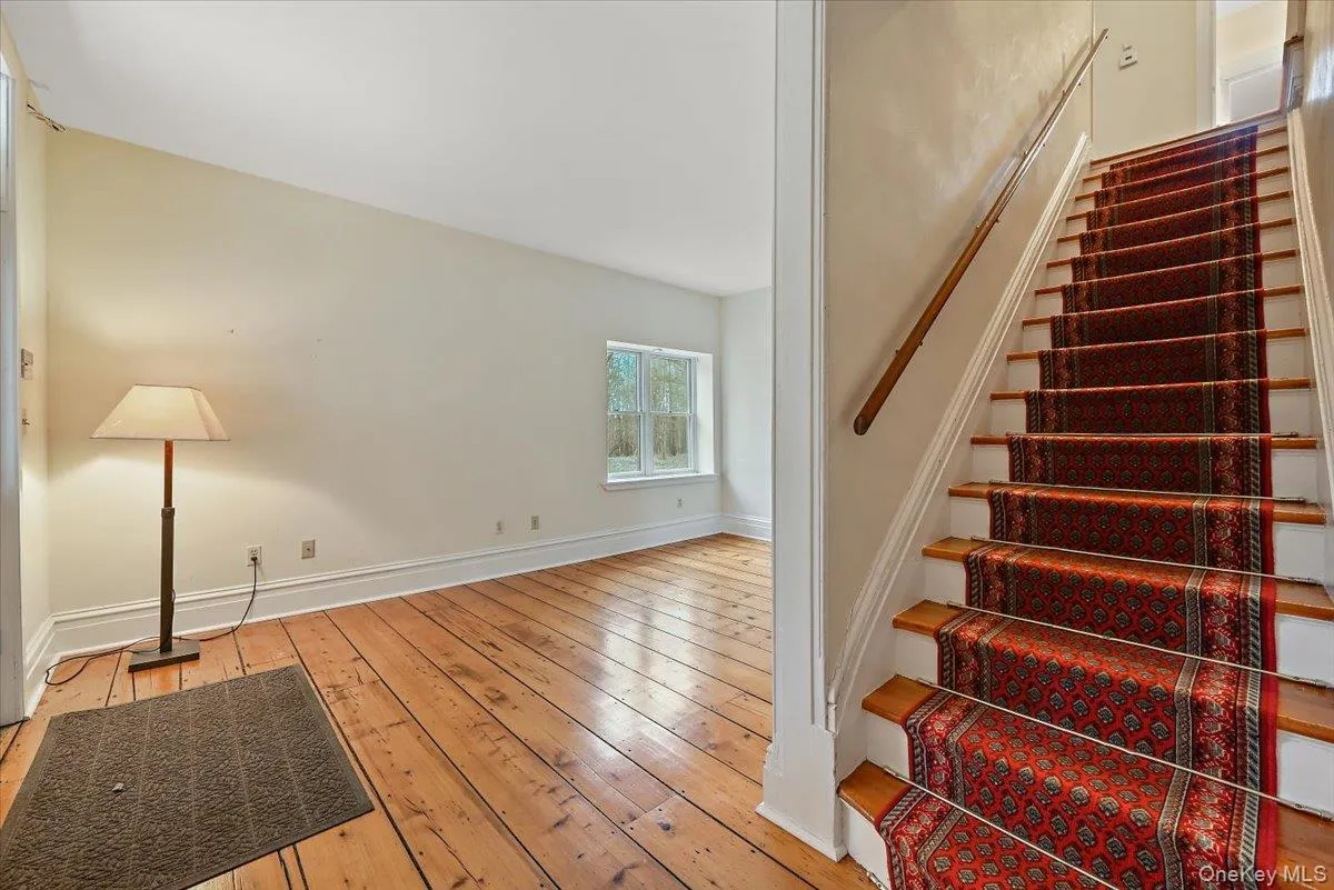 Stairway featuring hardwood / wood-style flooring and baseboards Stairway featuring hardwood / wood-style flooring and baseboards