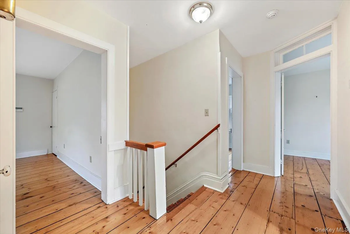 Hall with an upstairs landing and light wood-style floors Hall with an upstairs landing and light wood-style floors