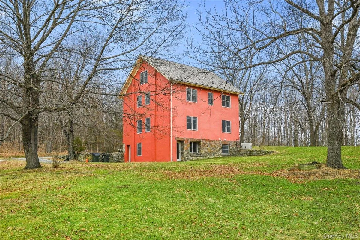 View of side of home with a yard, stucco siding, and stone siding View of side of home with a yard, stucco siding, and stone siding