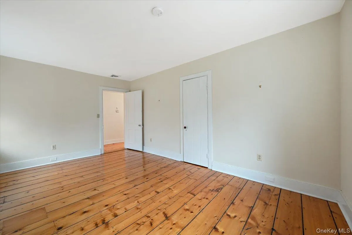 Unfurnished bedroom with hardwood / wood-style floors and baseboards Unfurnished bedroom with hardwood / wood-style floors and baseboards