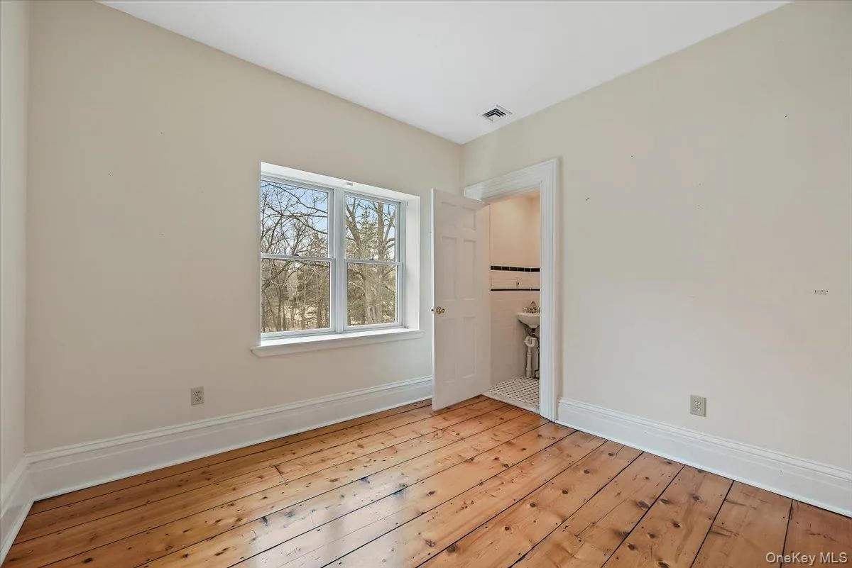 Unfurnished bedroom featuring wood-type flooring and baseboards Unfurnished bedroom featuring wood-type flooring and baseboards