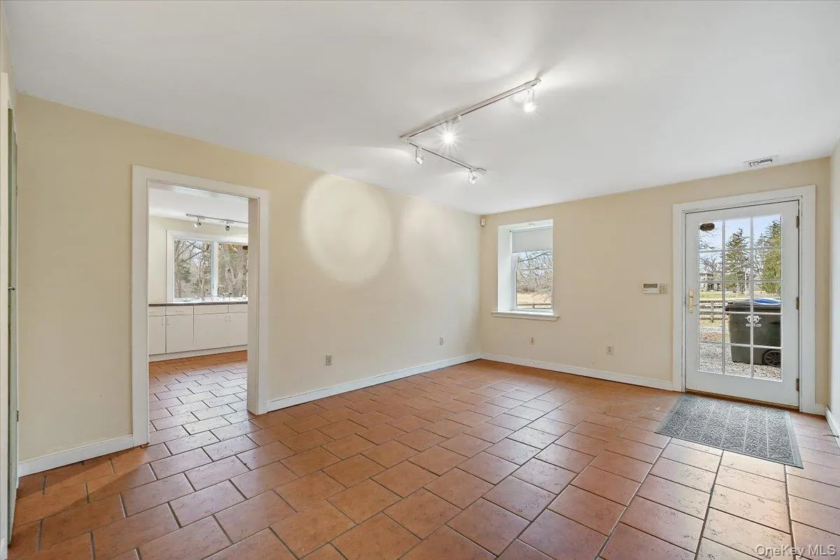 Unfurnished room featuring track lighting and light tile patterned flooring Unfurnished room featuring track lighting and light tile patterned flooring