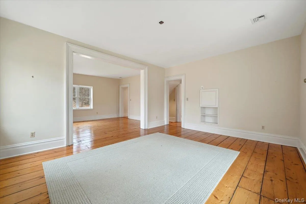 Spare room with light wood-style flooring and built in shelves Spare room with light wood-style flooring and built in shelves