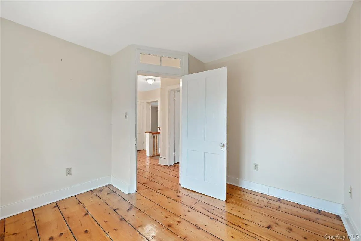 Empty room with baseboards and hardwood / wood-style flooring Empty room with baseboards and hardwood / wood-style flooring