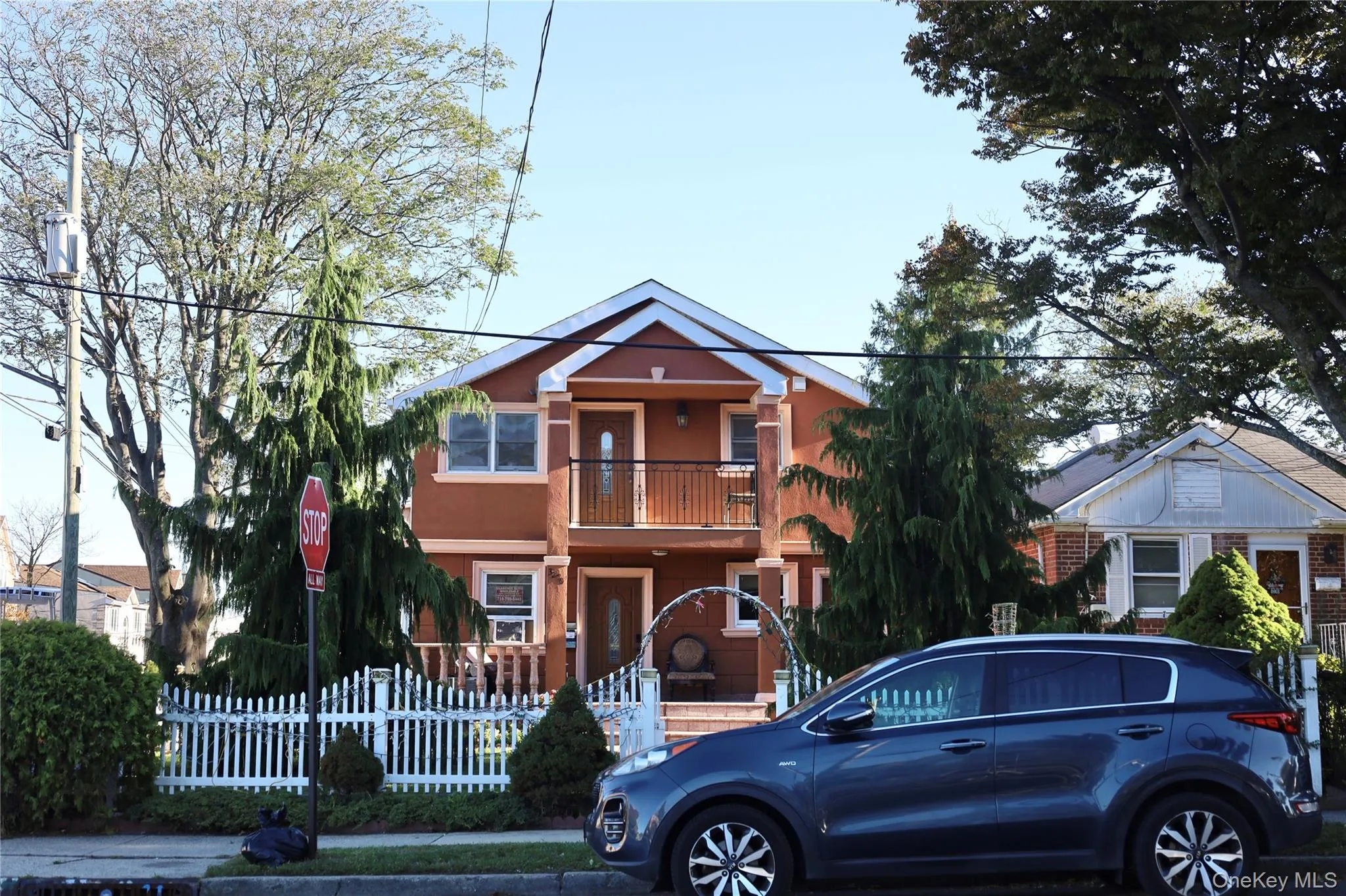 View of front of property featuring a fenced front yard, stucco siding, and a balcony View of front of property featuring a fenced front yard, stucco siding, and a balcony