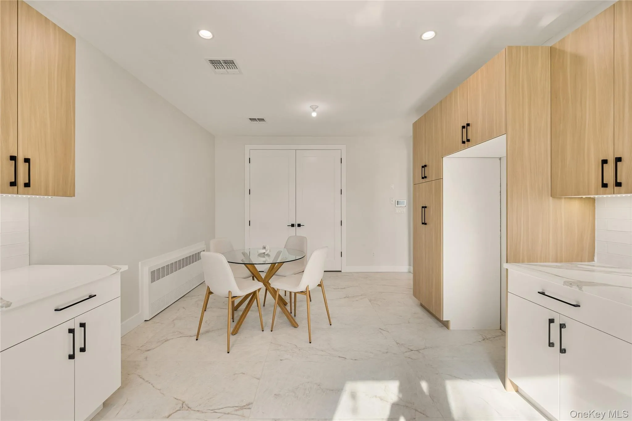 Dining area with radiator, recessed lighting, and light marble finish flooring Dining area with radiator, recessed lighting, and light marble finish flooring