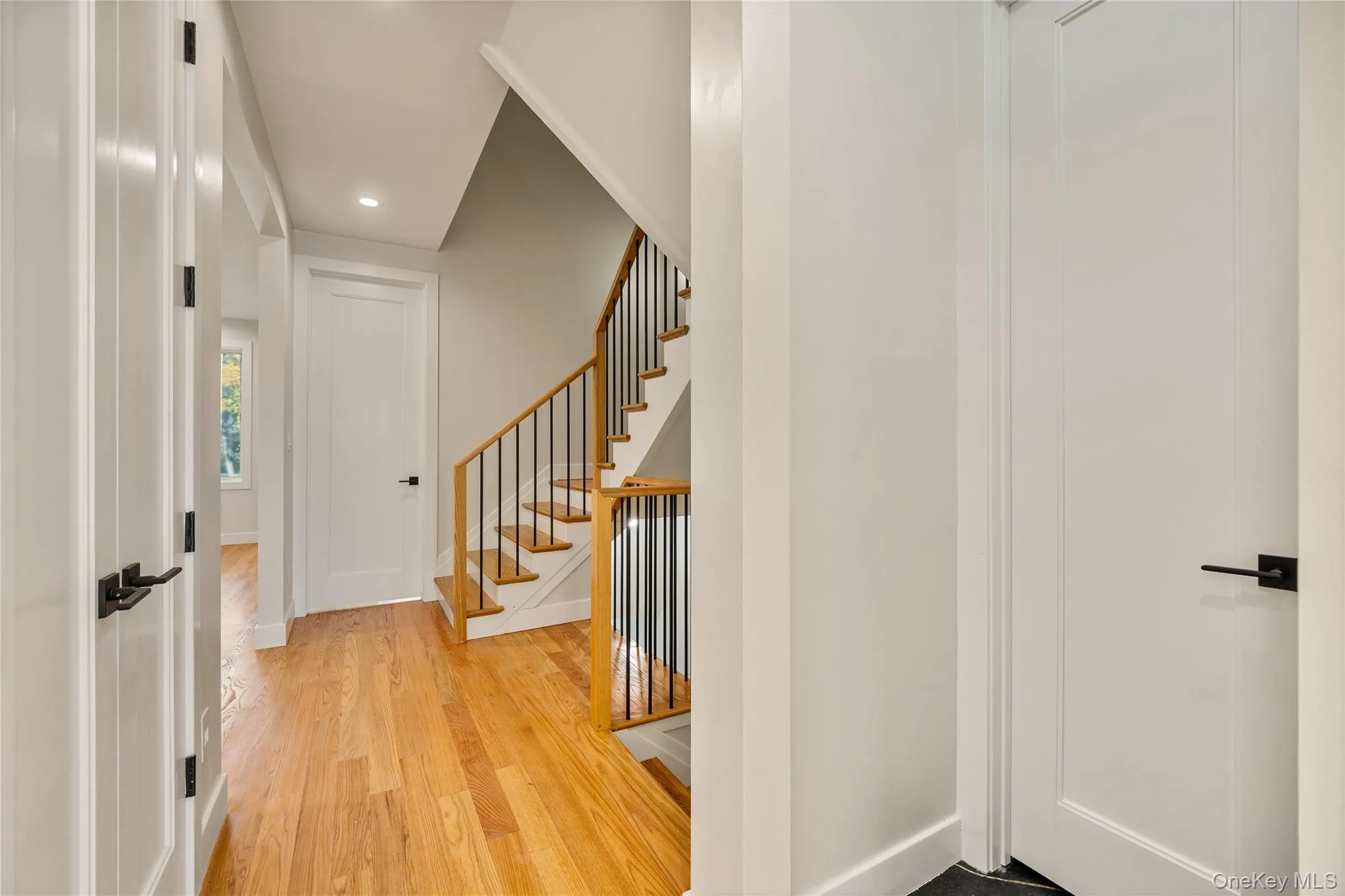 Corridor with light wood-type flooring, recessed lighting, and stairs Corridor with light wood-type flooring, recessed lighting, and stairs