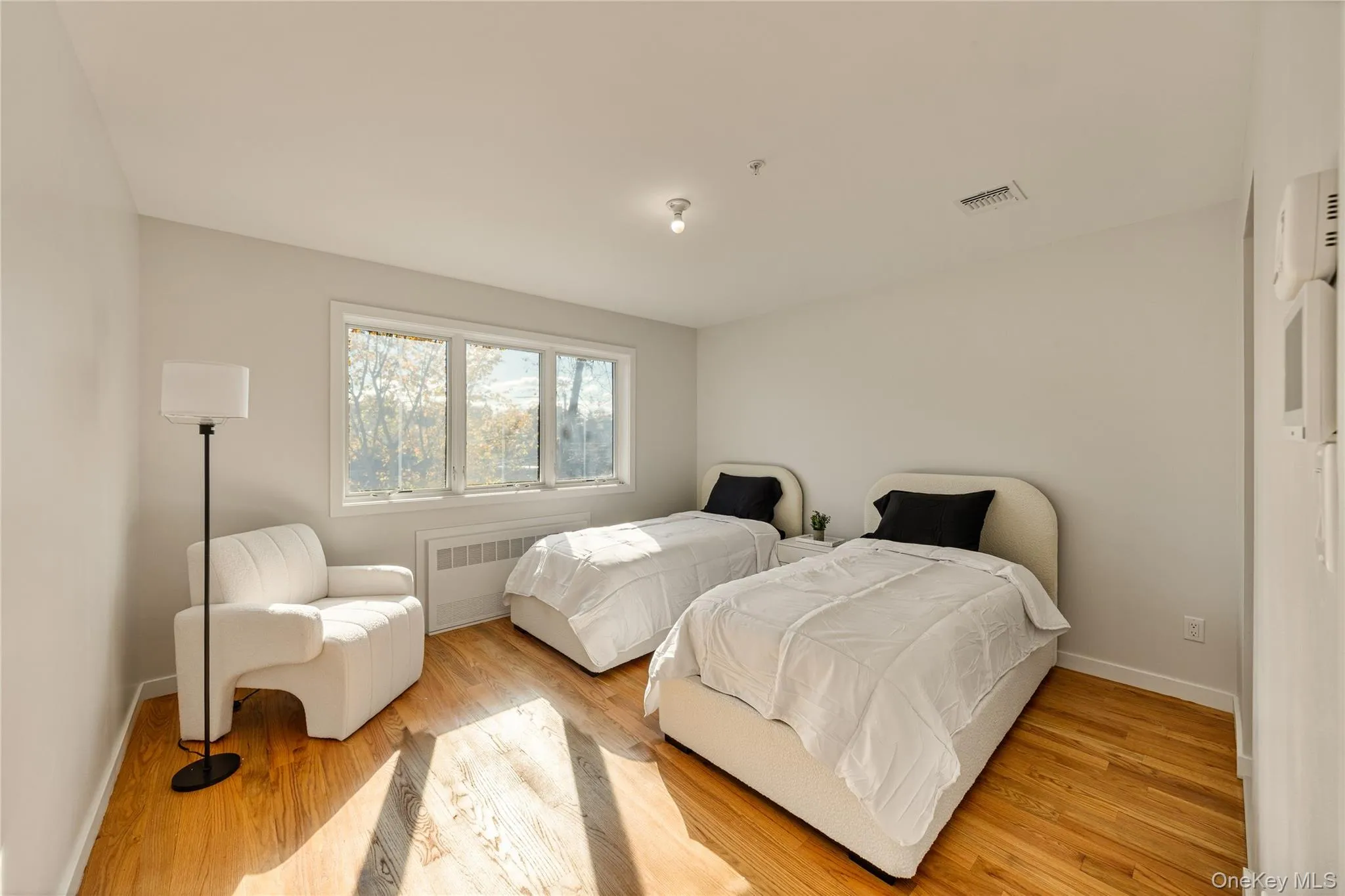 Bedroom with light wood finished floors and radiator Bedroom with light wood finished floors and radiator
