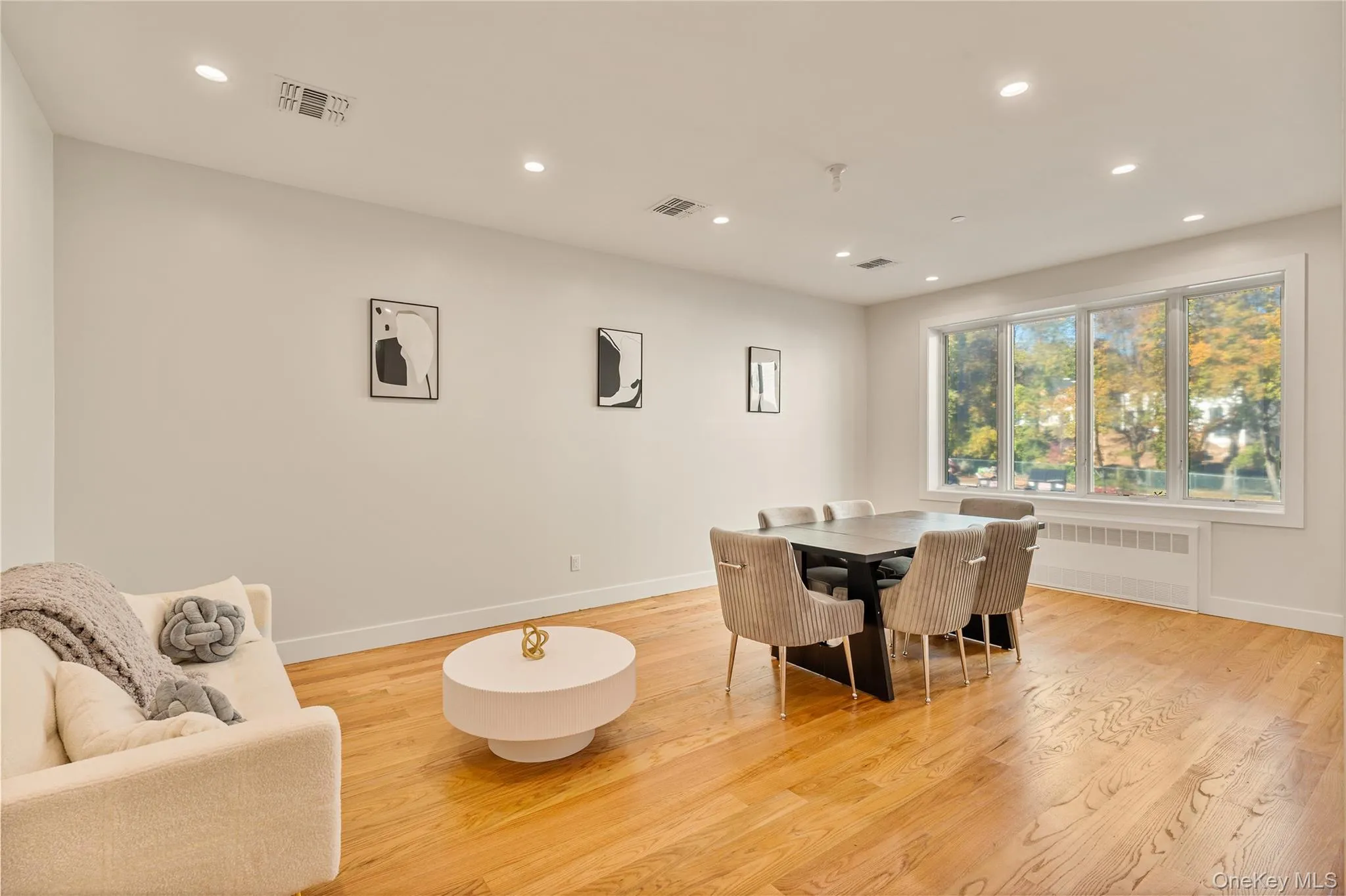 Dining room featuring recessed lighting, light wood finished floors, and radiator heating unit Dining room featuring recessed lighting, light wood finished floors, and radiator heating unit