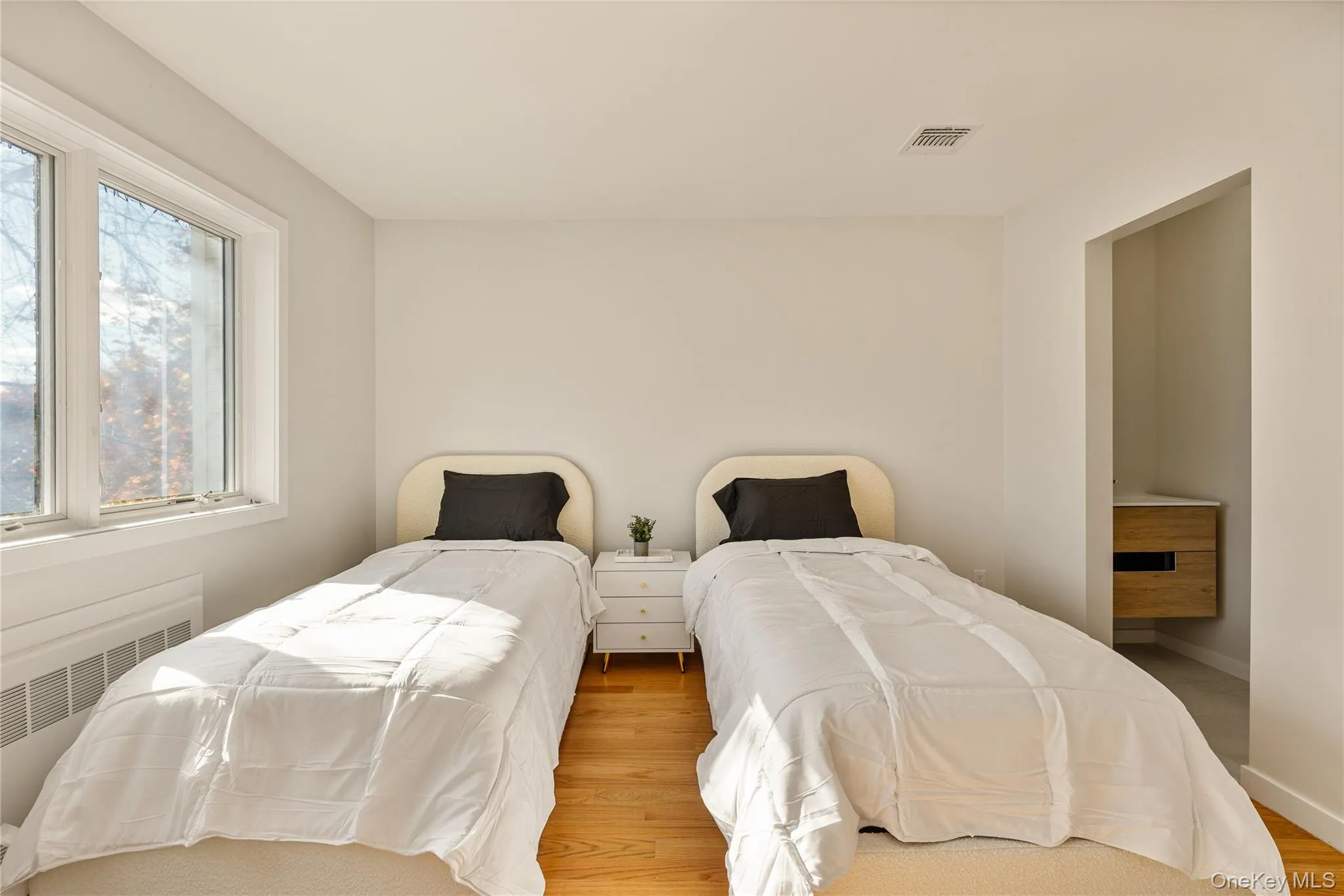 Bedroom featuring wood finished floors and radiator Bedroom featuring wood finished floors and radiator