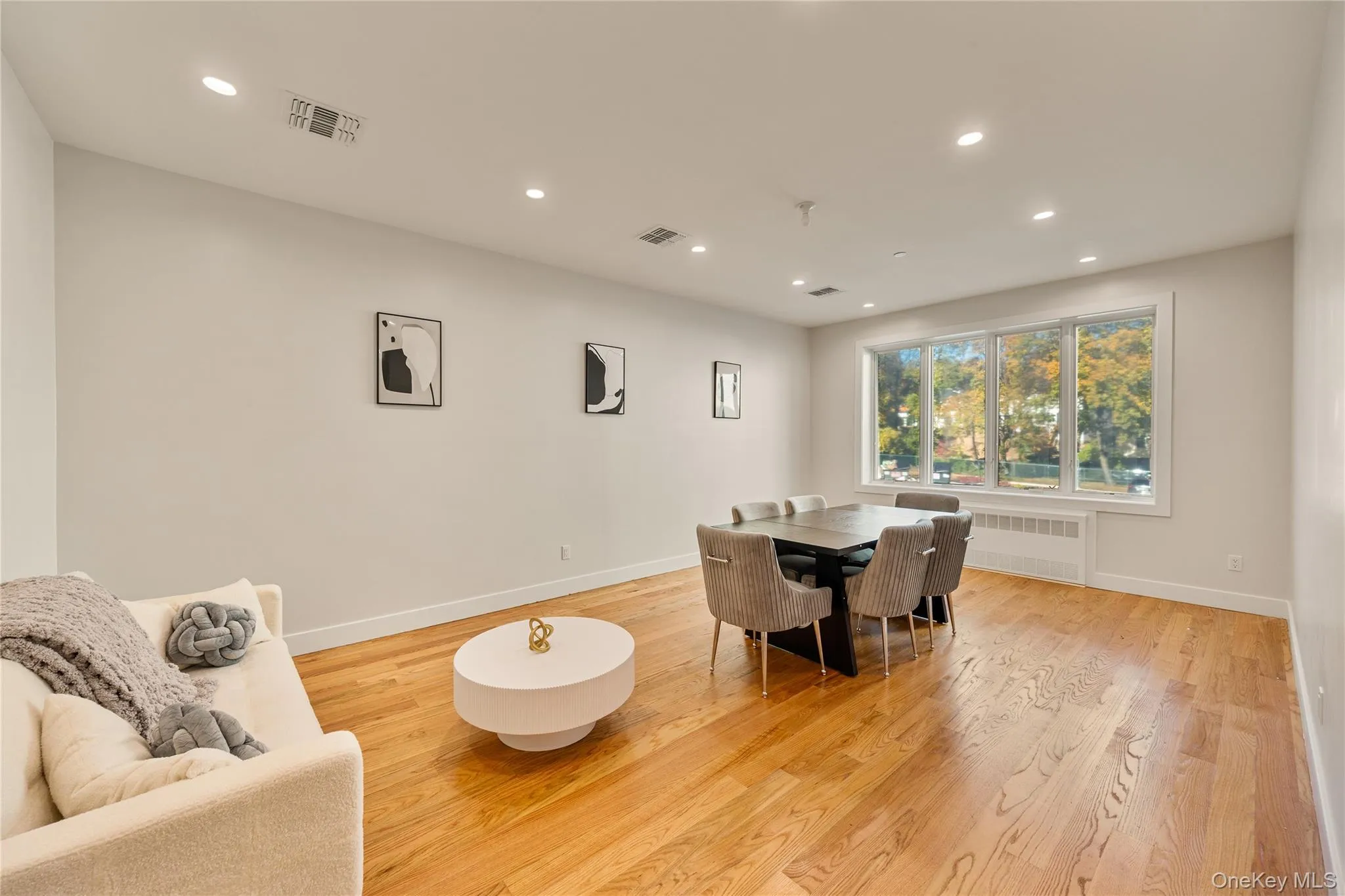 Dining space featuring recessed lighting, light wood-style flooring, and radiator heating unit Dining space featuring recessed lighting, light wood-style flooring, and radiator heating unit