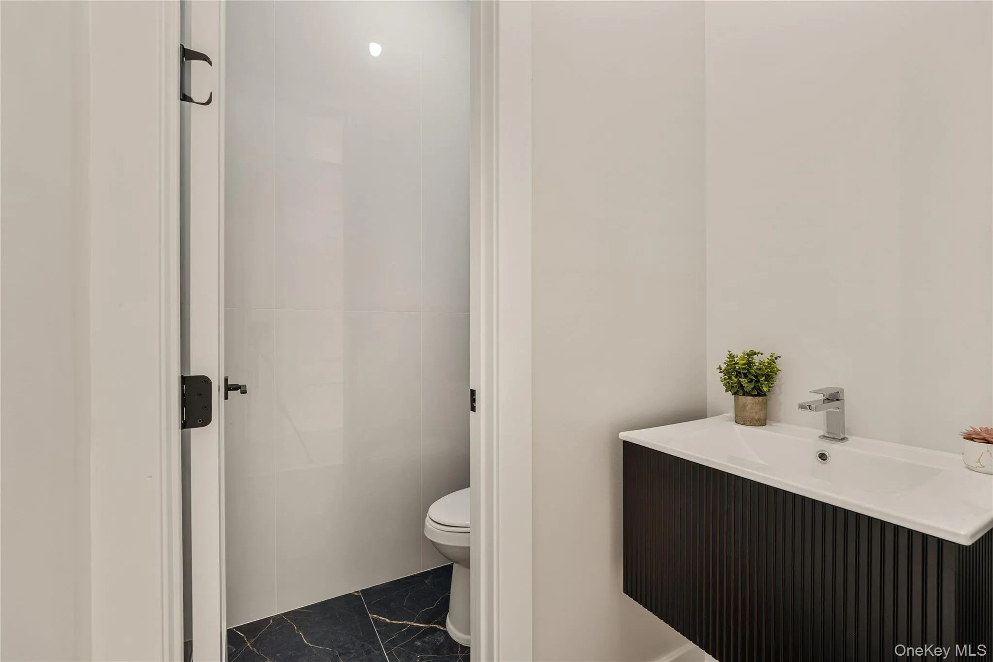 Bathroom featuring vanity and marble finish flooring Bathroom featuring vanity and marble finish flooring
