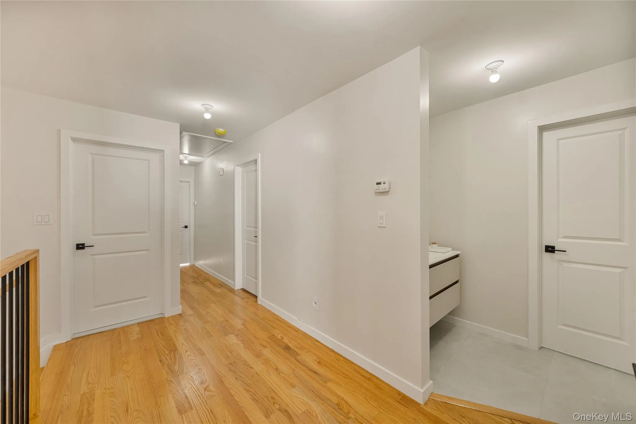 Hallway with attic access and light wood finished floors Hallway with attic access and light wood finished floors