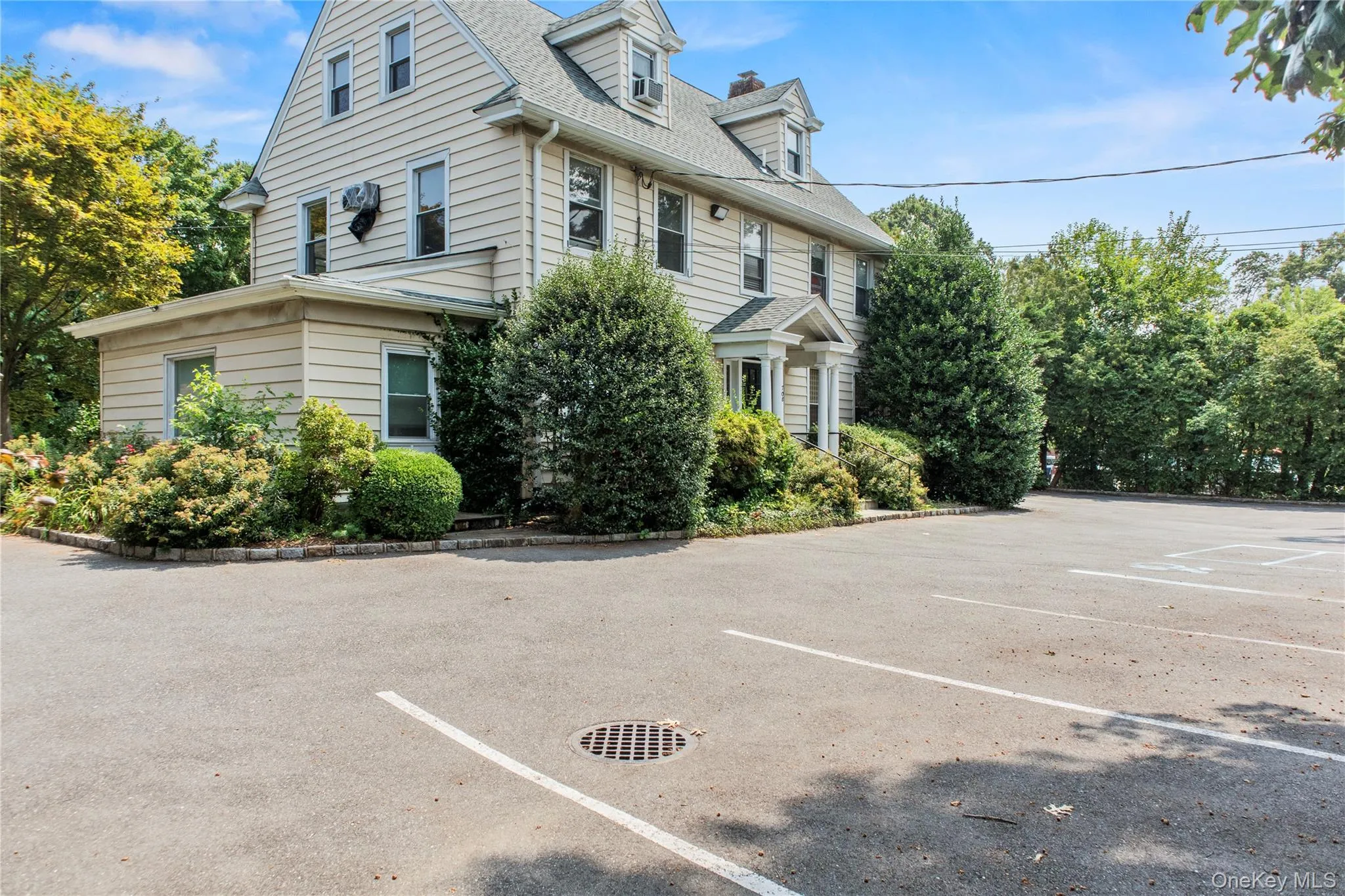 View of side of property featuring uncovered parking and a shingled roof View of side of property featuring uncovered parking and a shingled roof