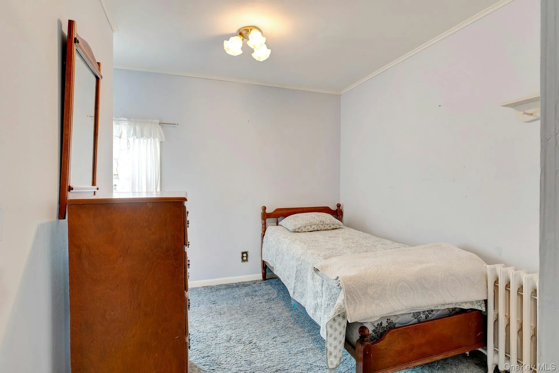 Bedroom featuring radiator, carpet floors, and ornamental molding Bedroom featuring radiator, carpet floors, and ornamental molding