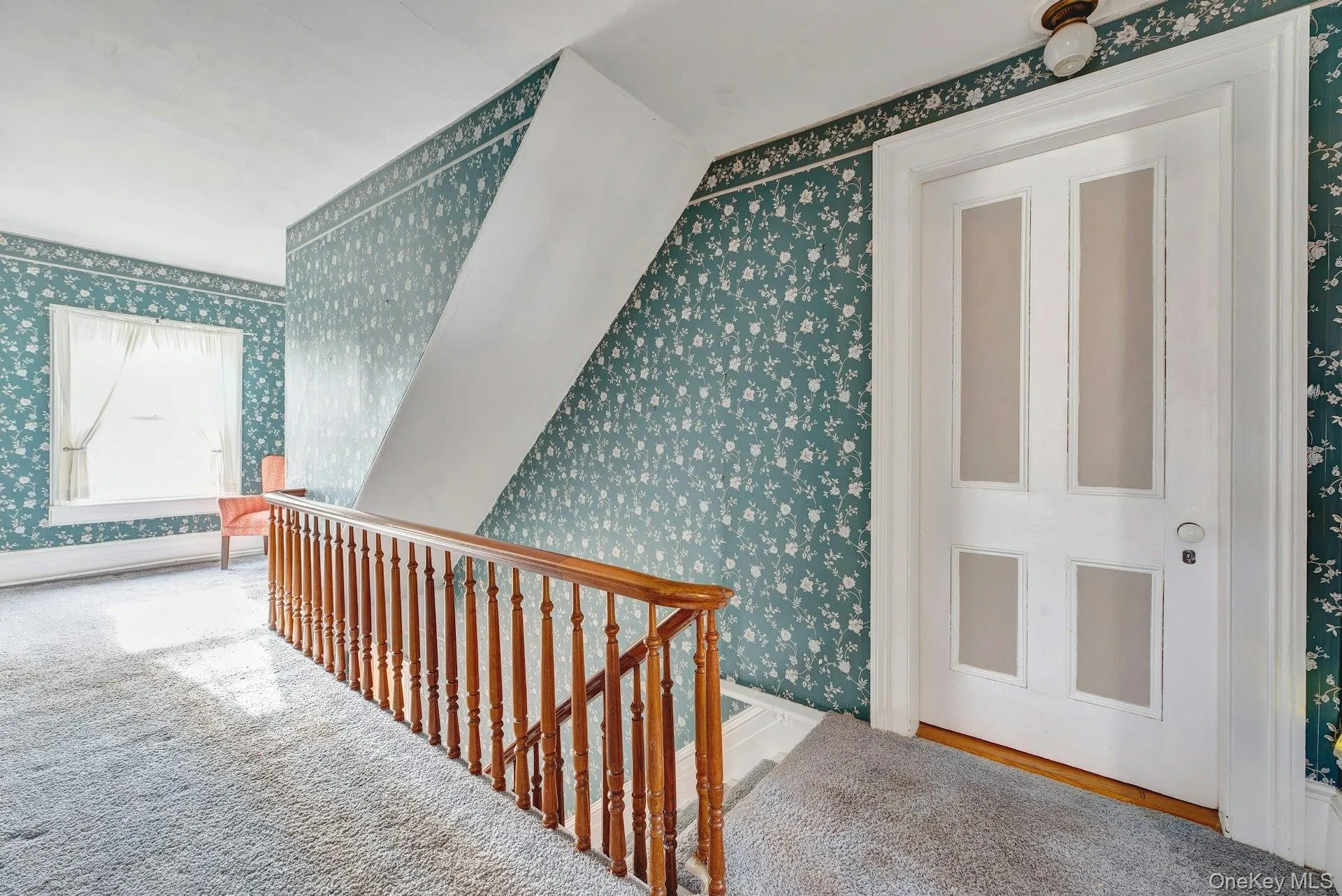 Hallway with an upstairs landing and wallpapered walls Hallway with an upstairs landing and wallpapered walls