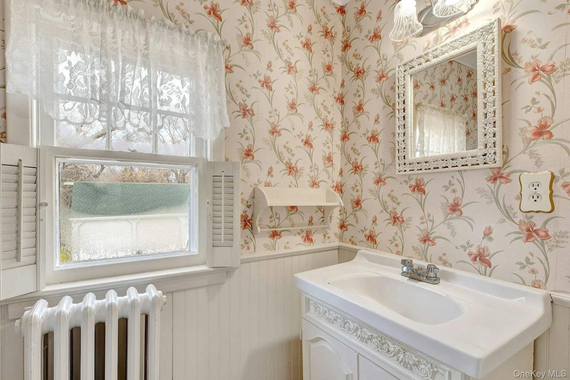 Bathroom with wainscoting, wallpapered walls, radiator, and vanity Bathroom with wainscoting, wallpapered walls, radiator, and vanity