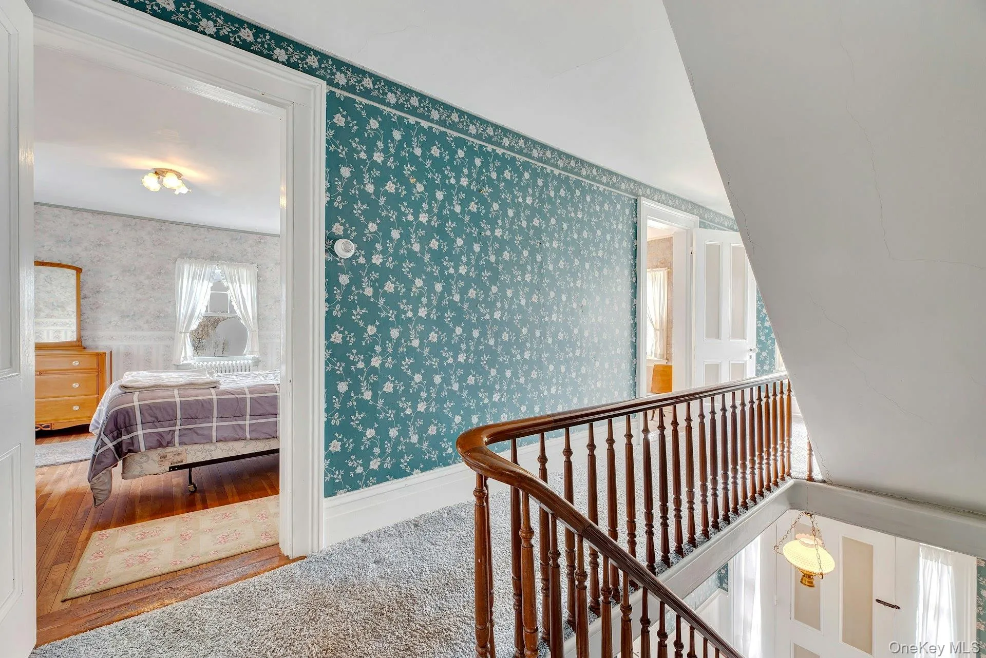 Hallway featuring wallpapered walls and baseboards Hallway featuring wallpapered walls and baseboards