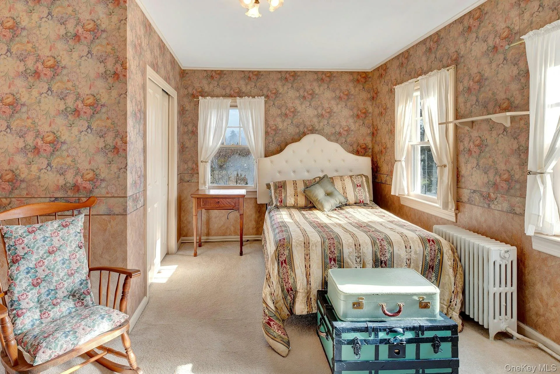 Carpeted bedroom with radiator heating unit, wallpapered walls, and a closet Carpeted bedroom with radiator heating unit, wallpapered walls, and a closet