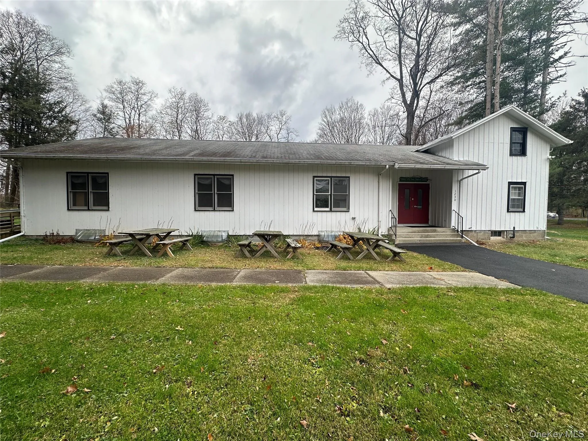 View of front of home with a front lawn and a shingled roof View of front of home with a front lawn and a shingled roof