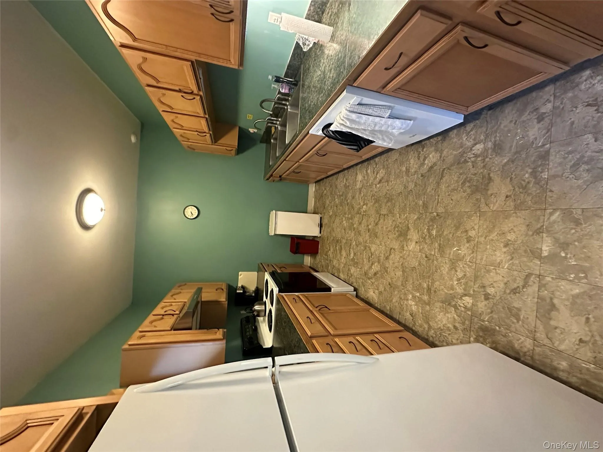 Kitchen featuring refrigerator, dark countertops, stove, dishwasher, and under cabinet range hood Kitchen featuring refrigerator, dark countertops, stove, dishwasher, and under cabinet range hood